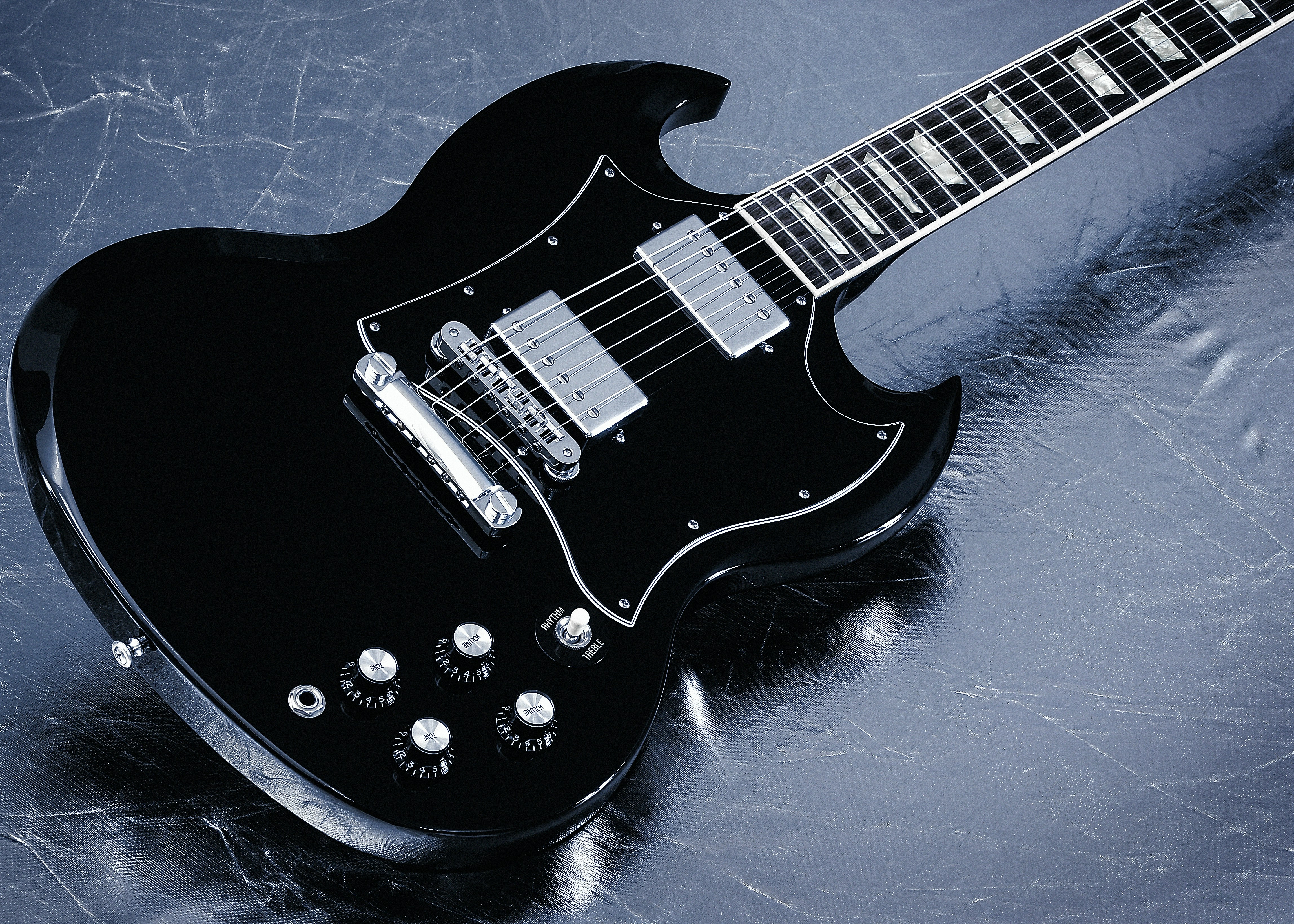 A black electric guitar on a shiny surface