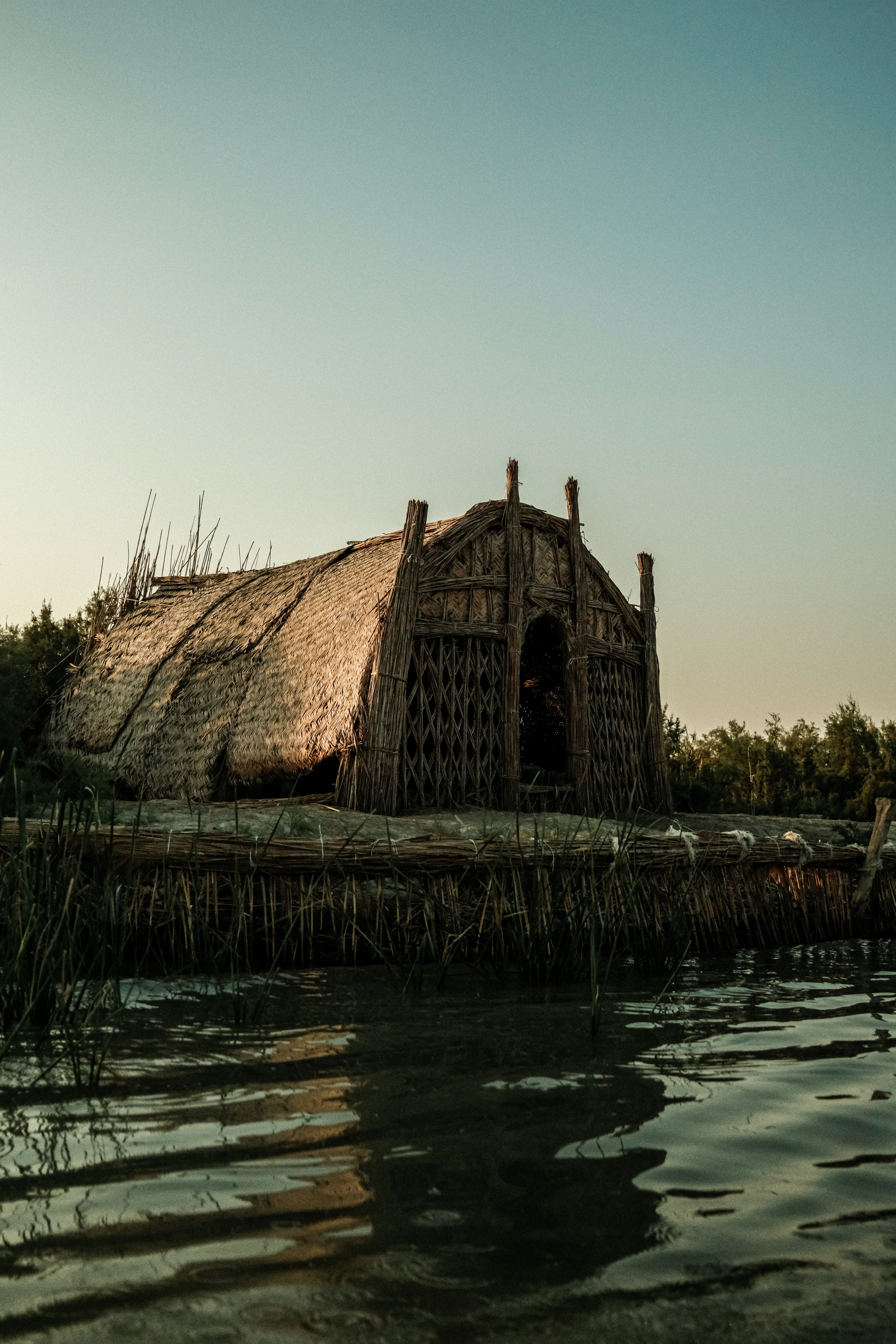Thatched hut on a wooden platform by the water.