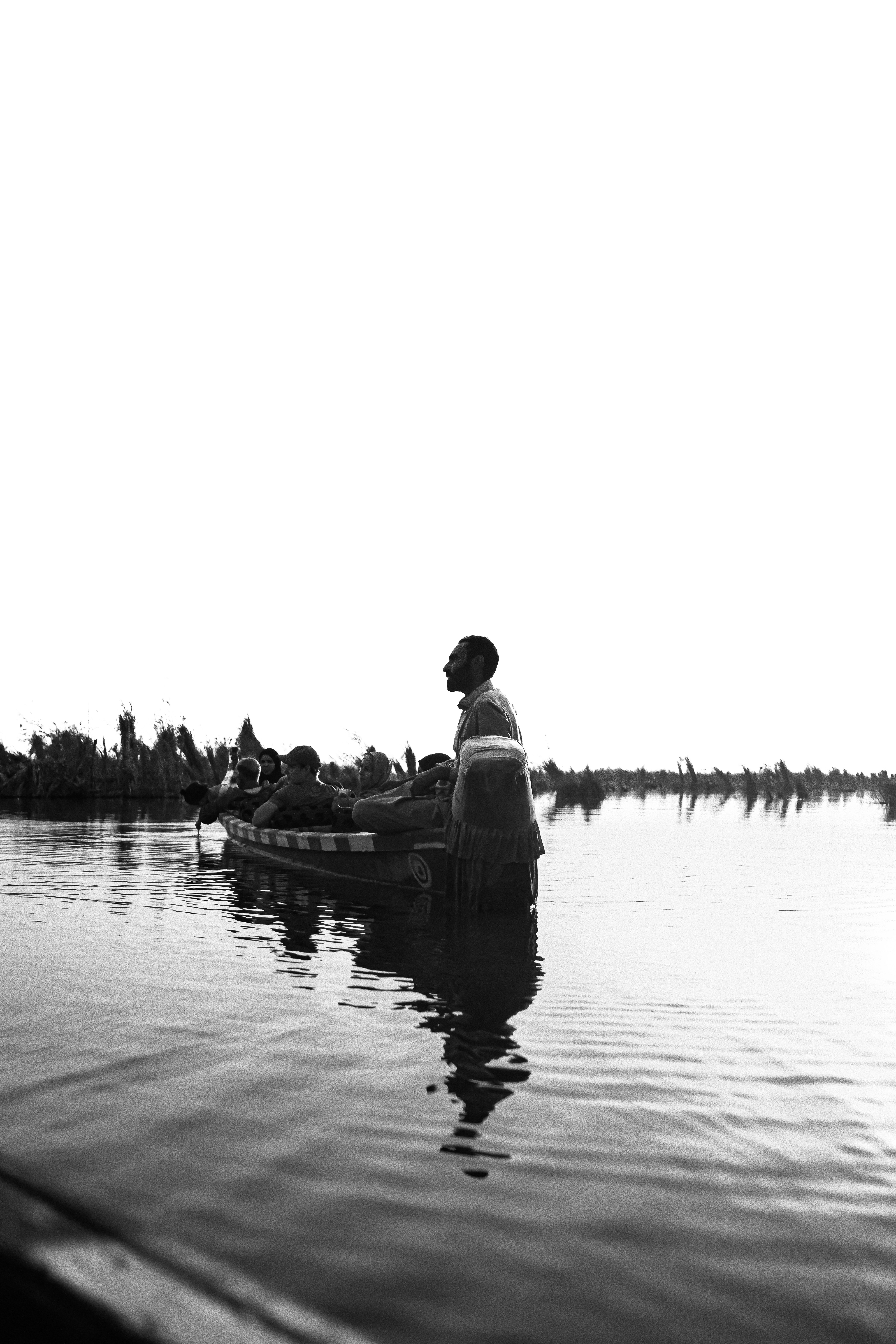 People in a boat on a calm body of water.