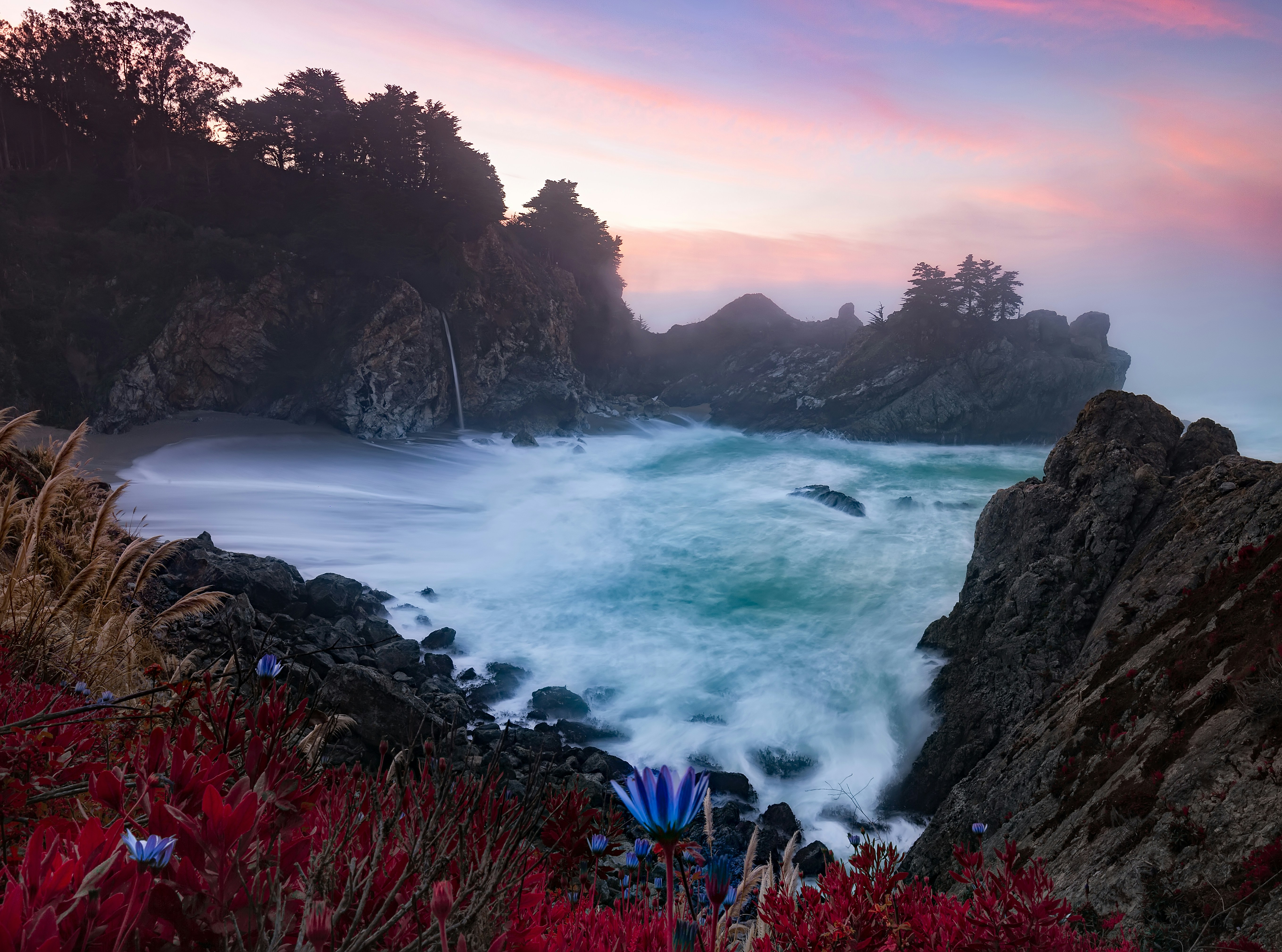 Las olas rompen contra la costa rocosa al atardecer