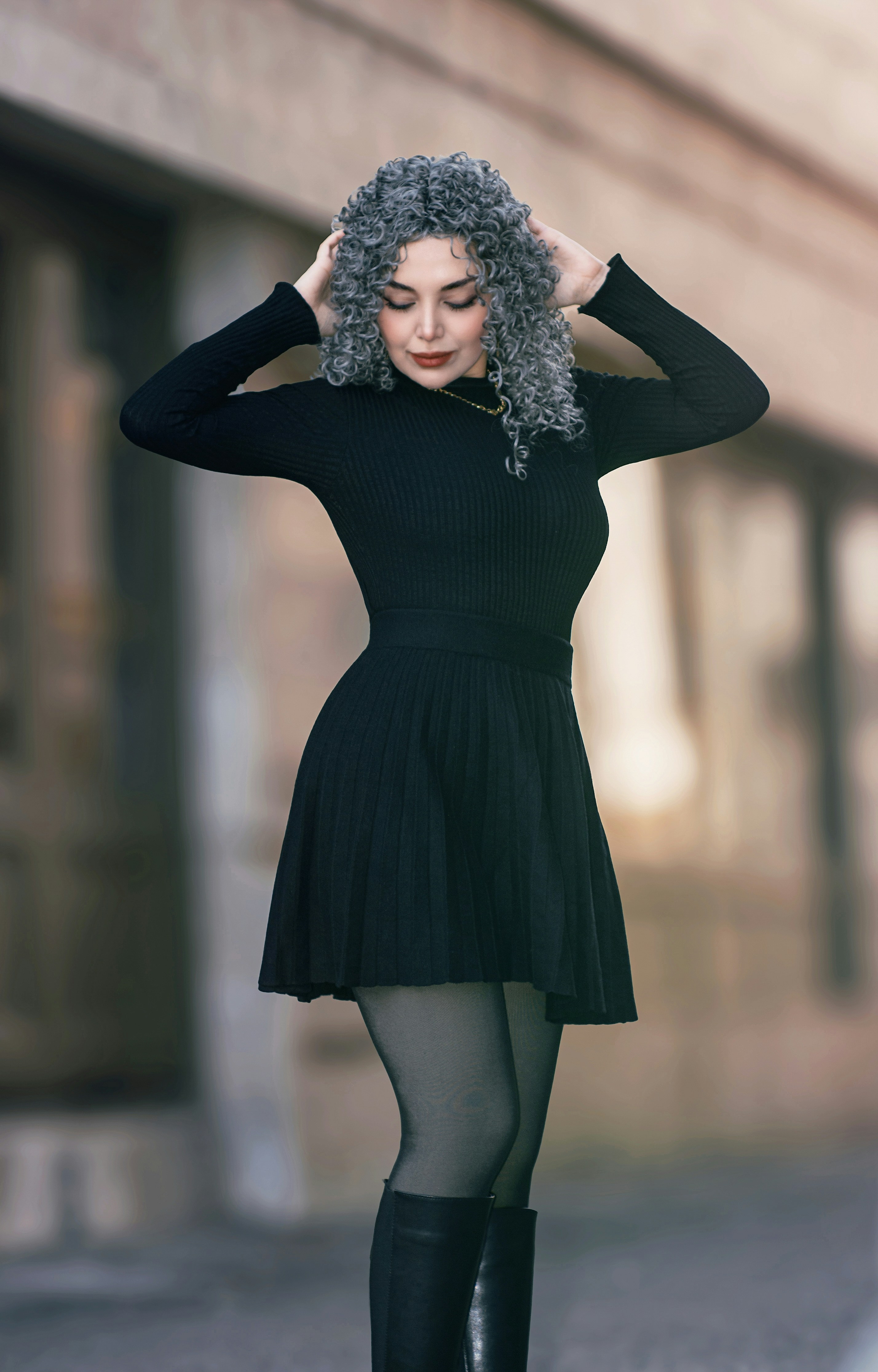 Woman with curly gray hair in black dress