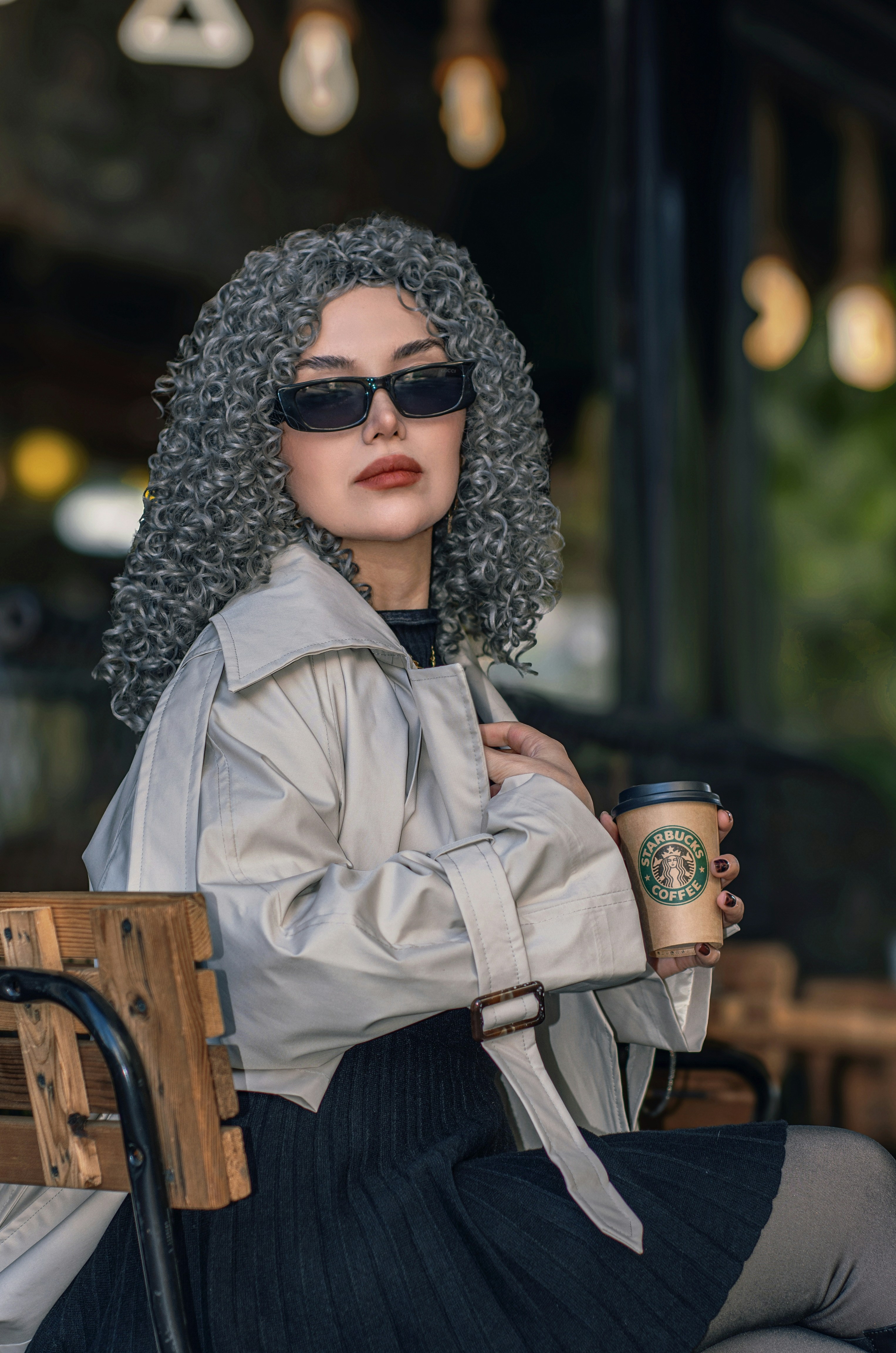 Woman with curly grey hair holding coffee cup