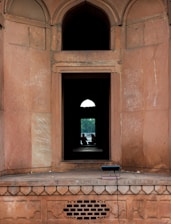 Two people silhouetted in an arched doorway looking outside.