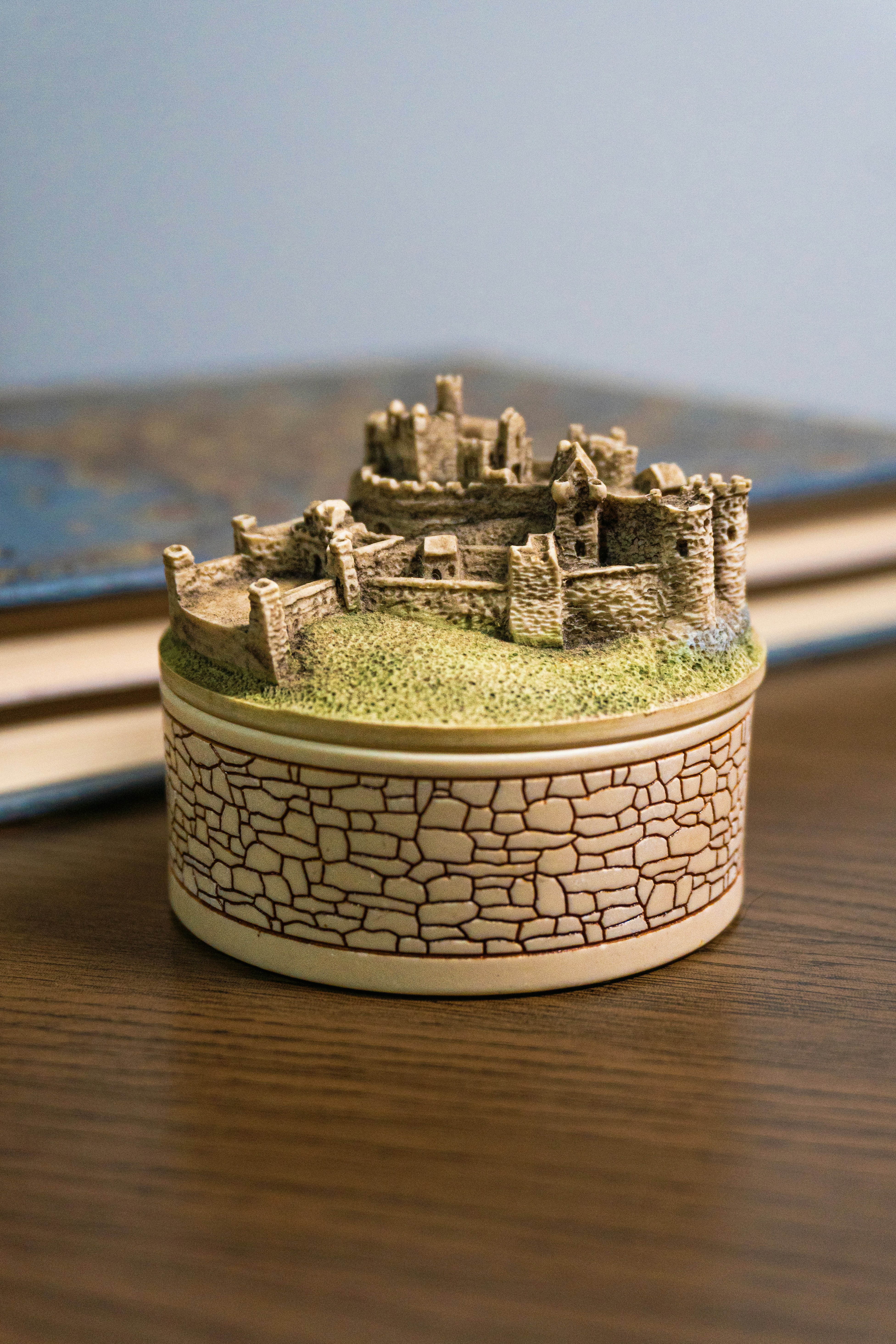Miniature castle sits on a stone-patterned box.