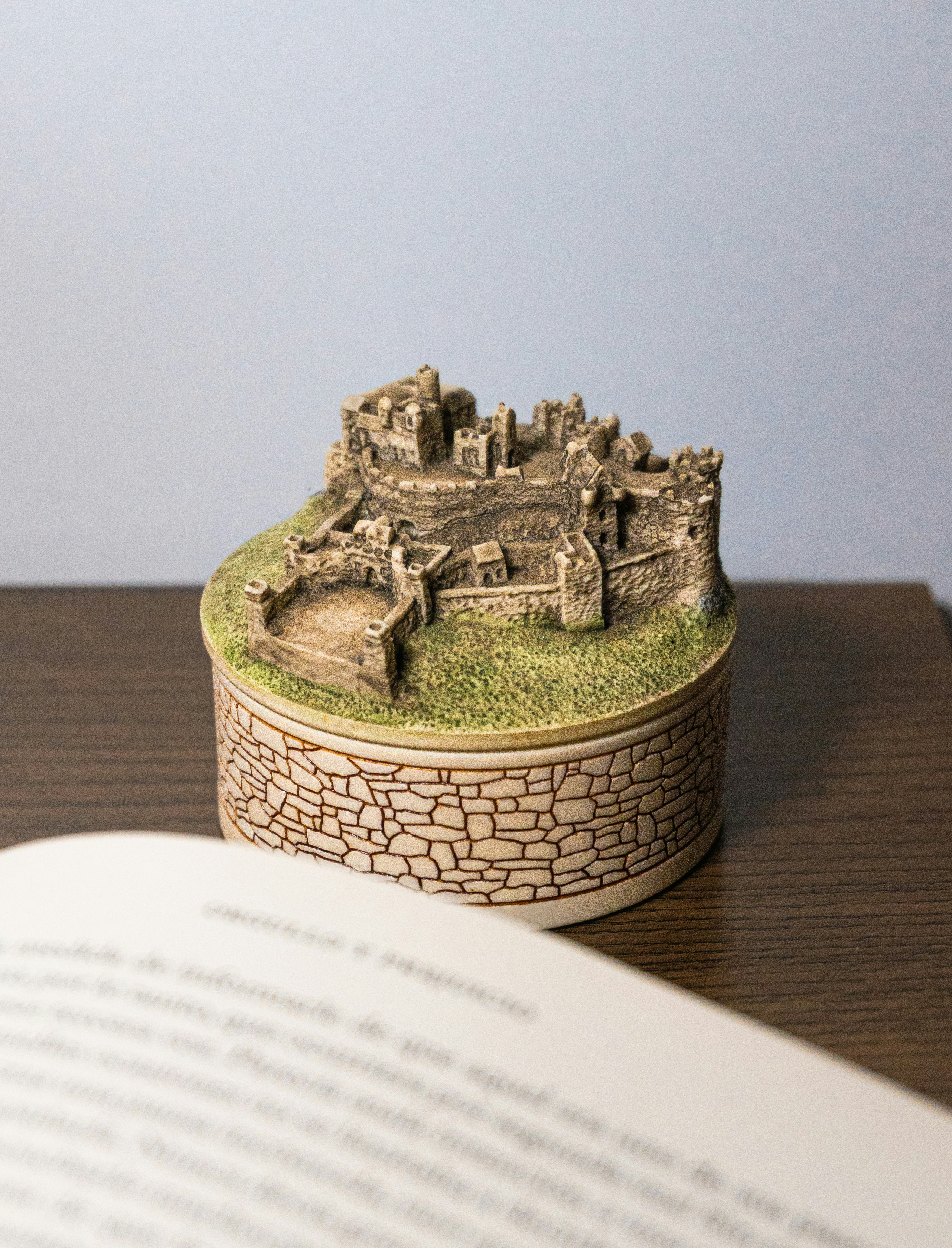 Miniature castle sits atop a stone box.
