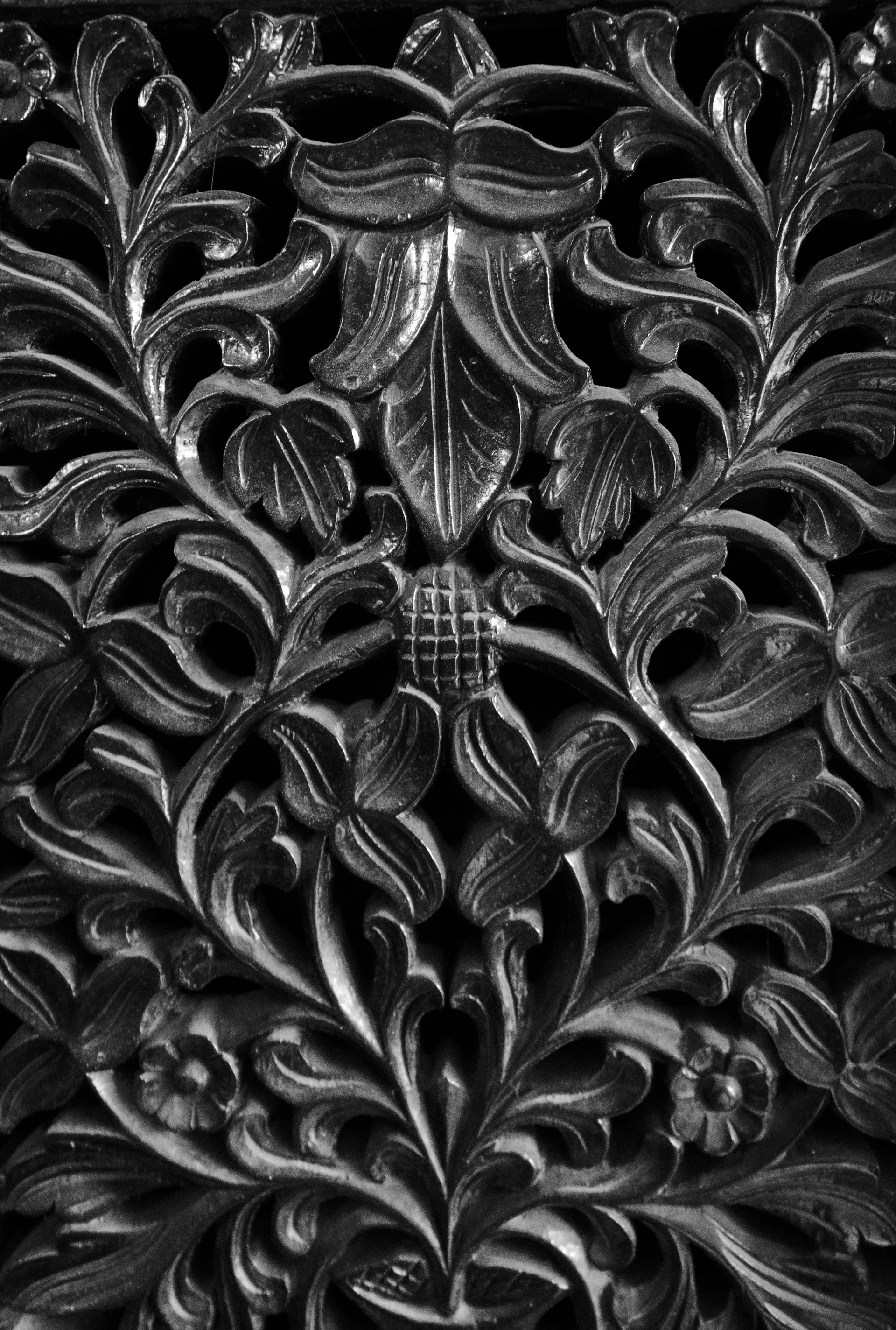 Intricate floral wood carving with dark background