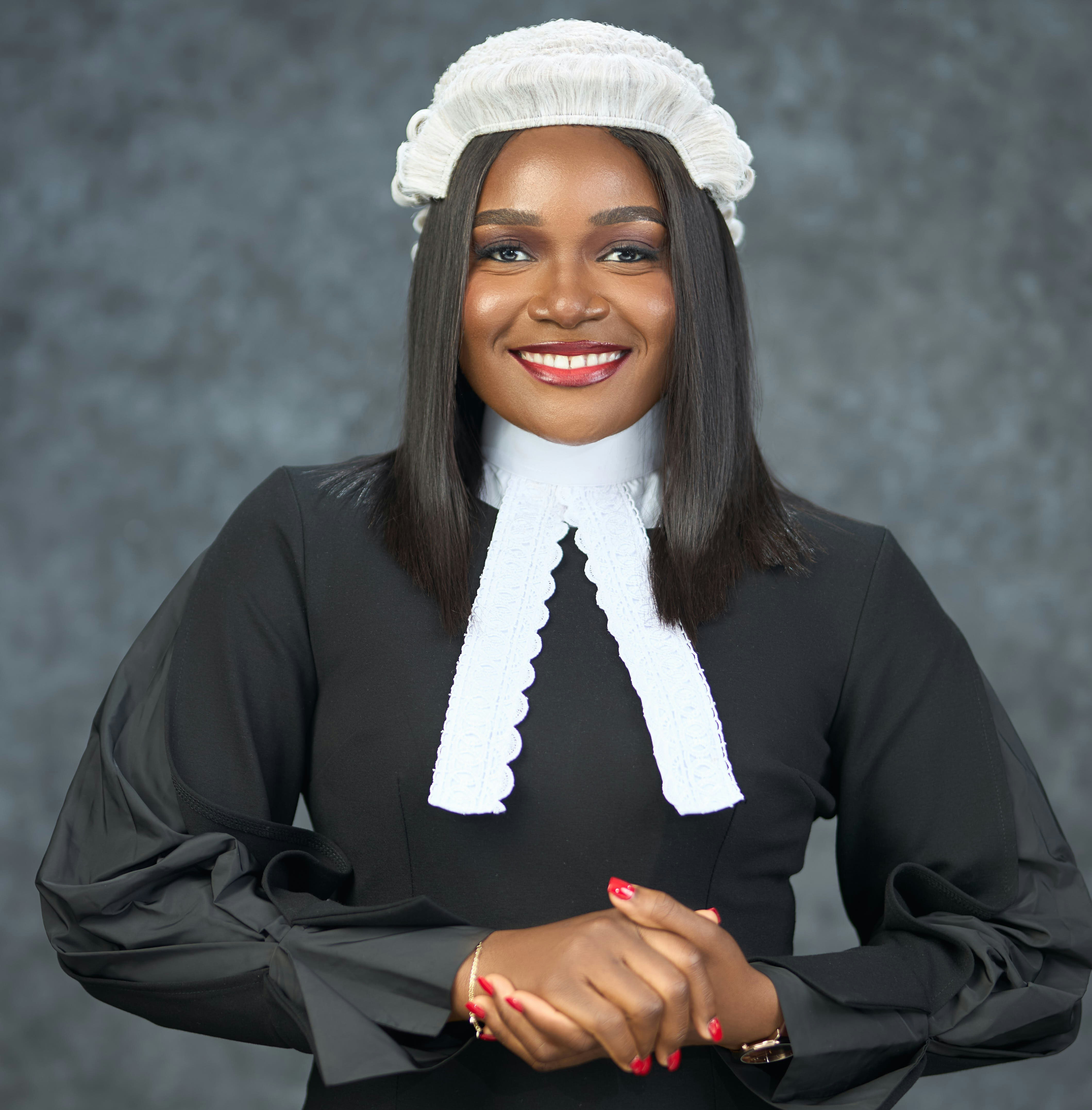 A woman in legal attire smiles at the camera.