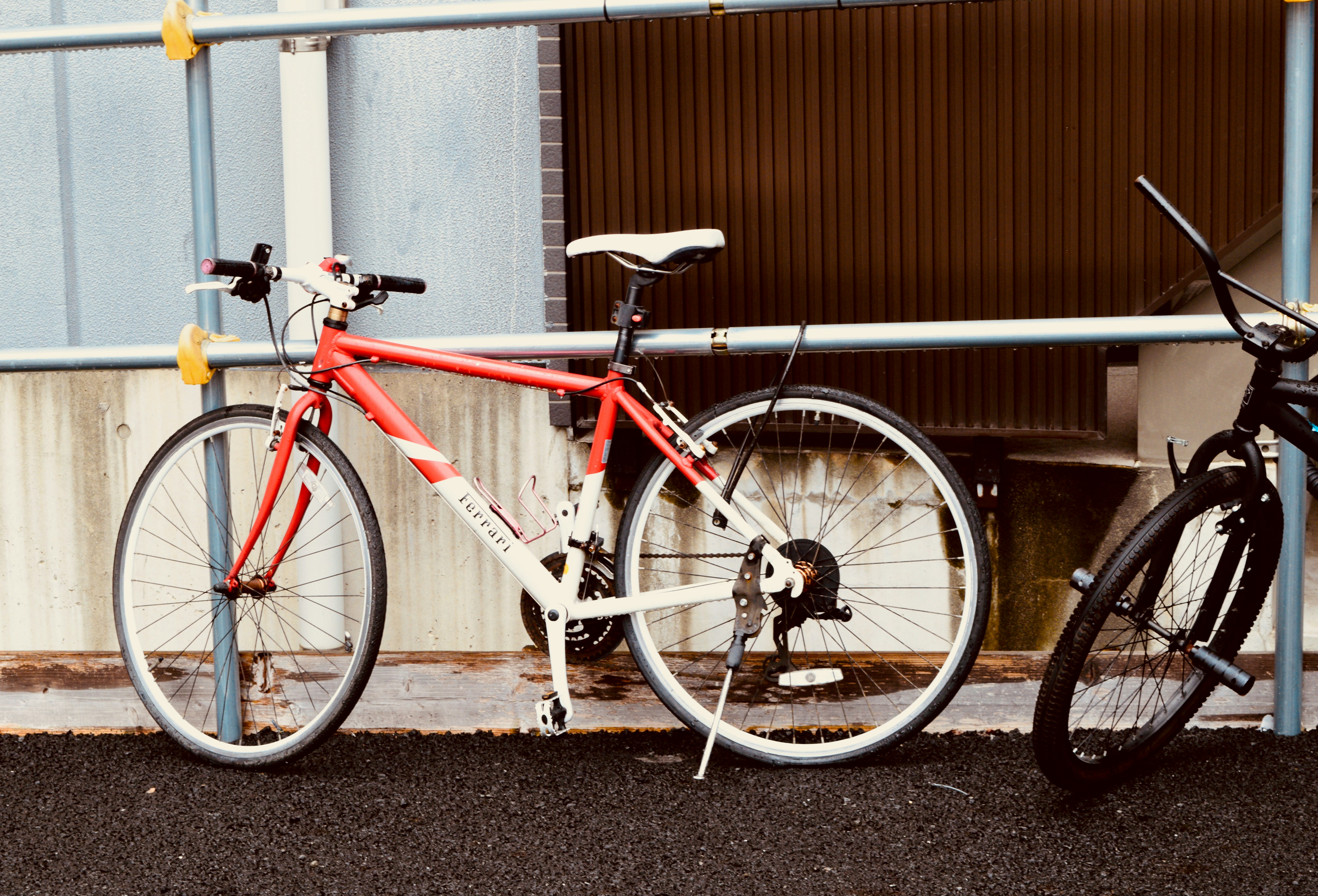 A red and white bicycle parked next to a wall.