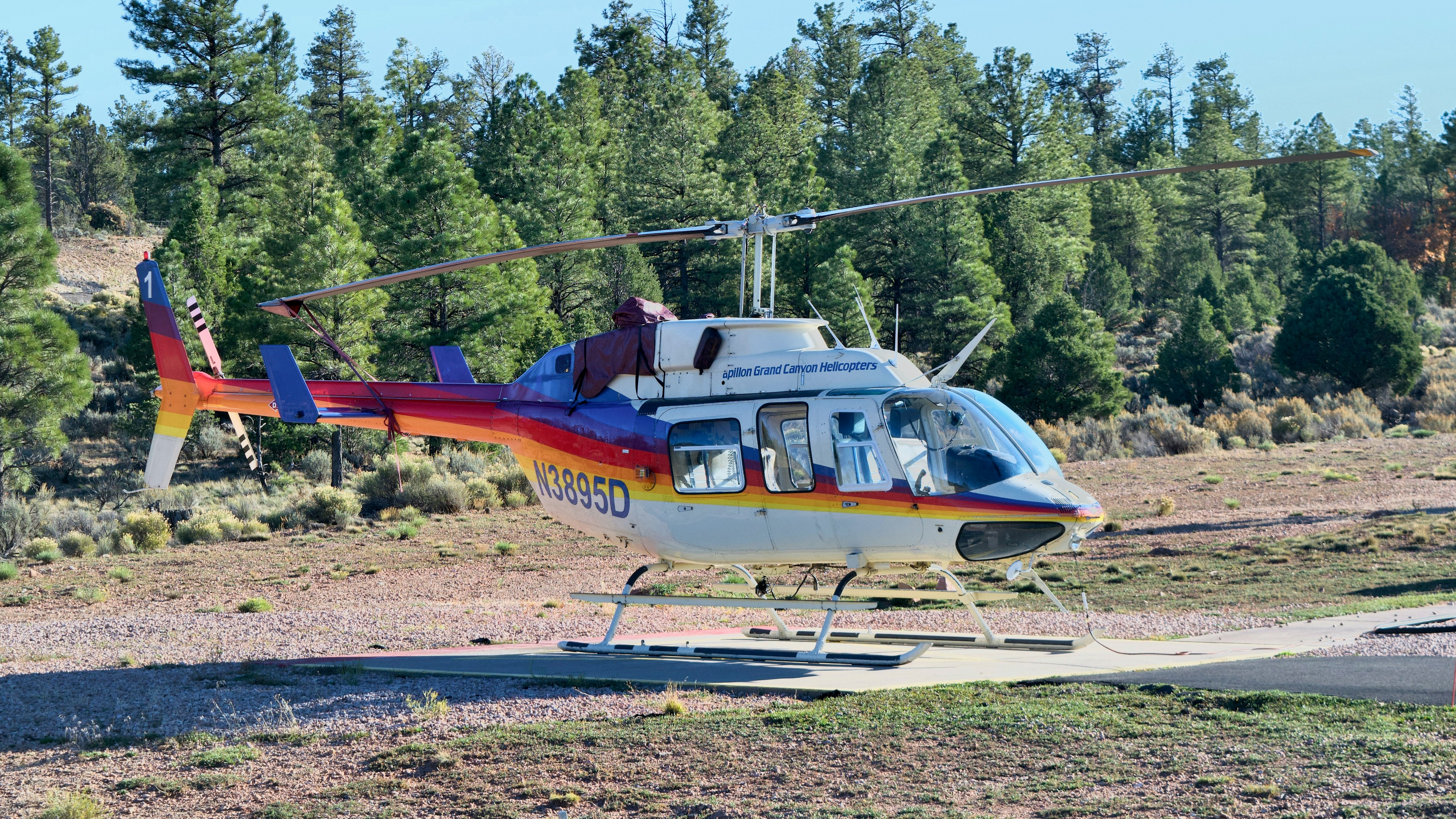 A colorful helicopter lands on a helipad.