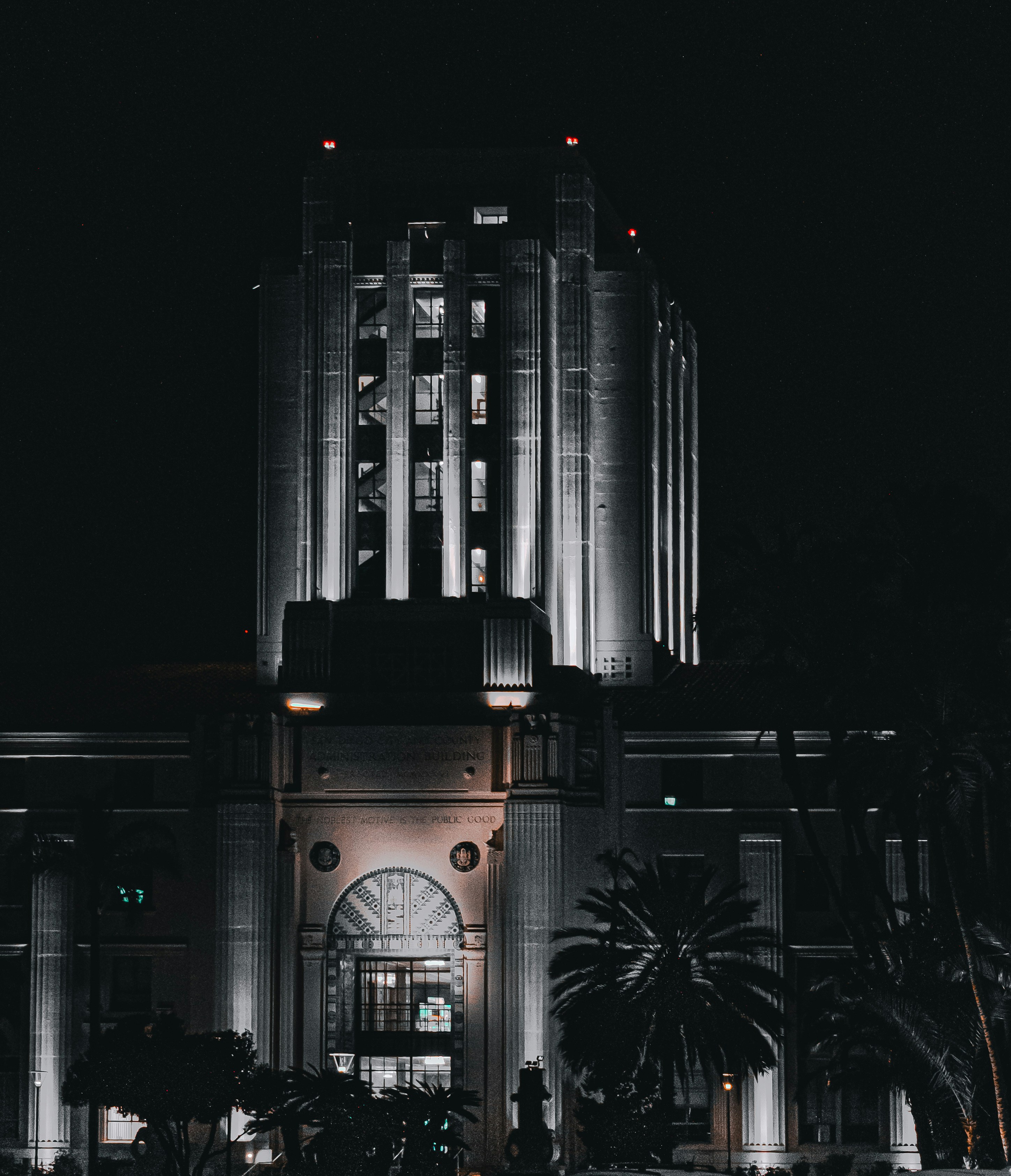 Lit building at night with palm trees