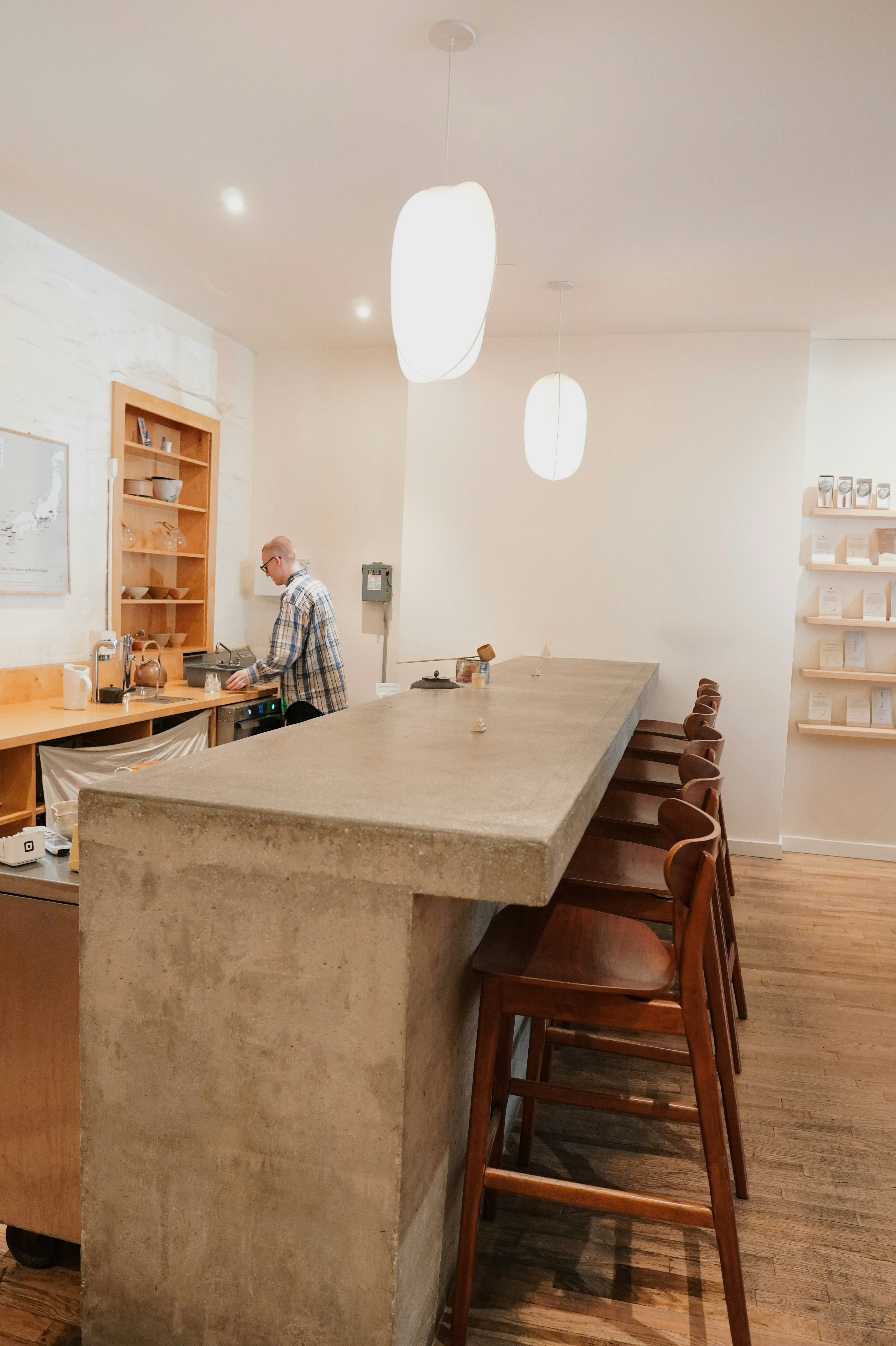 Man preparing drinks behind a long counter
