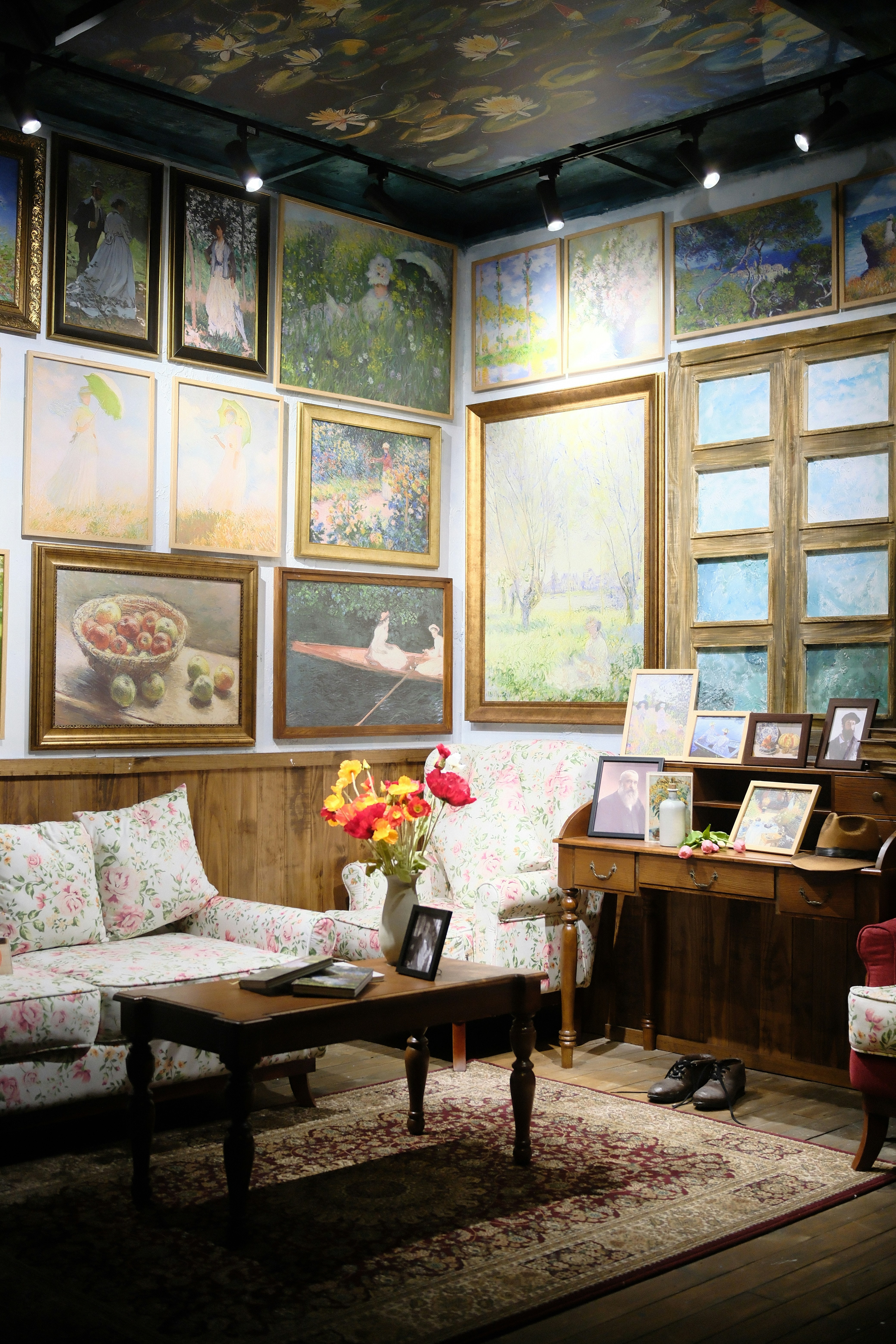 Living room filled with paintings and antique furniture.