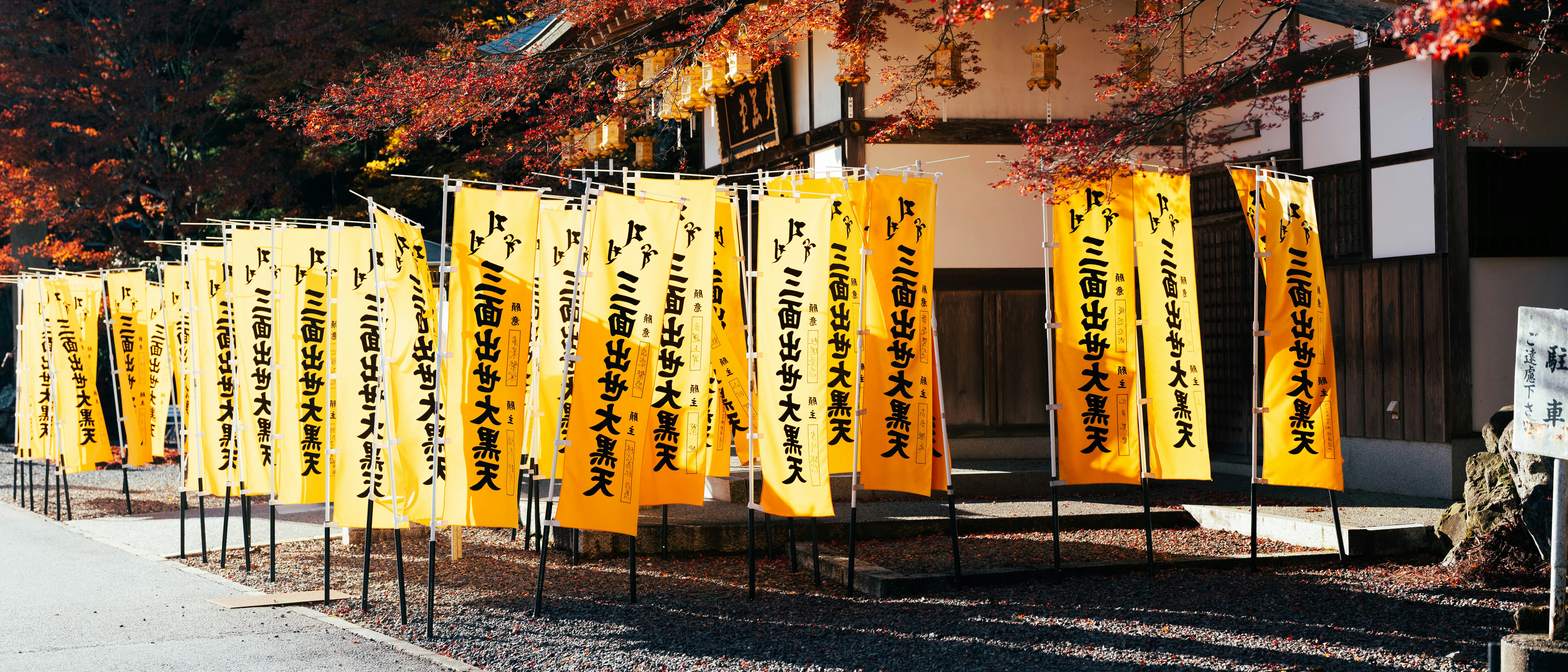 Yellow banners with japanese text hang outside a building.