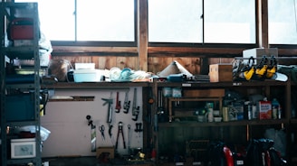A cluttered workshop shelf with tools and supplies.