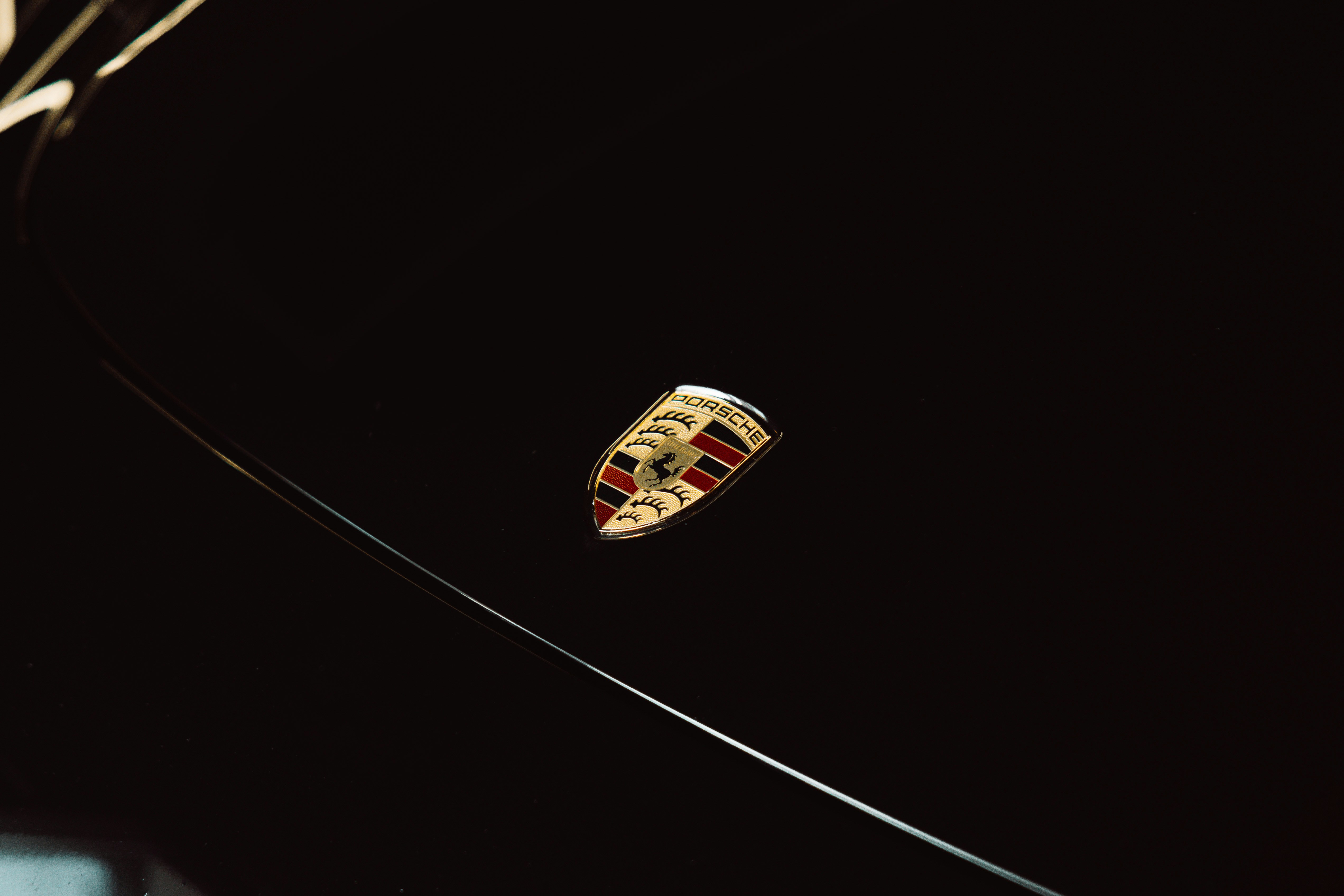Close-up of a porsche emblem on a black background