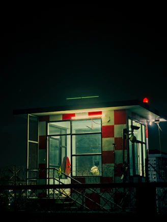 A red and white checkered booth illuminated at night.