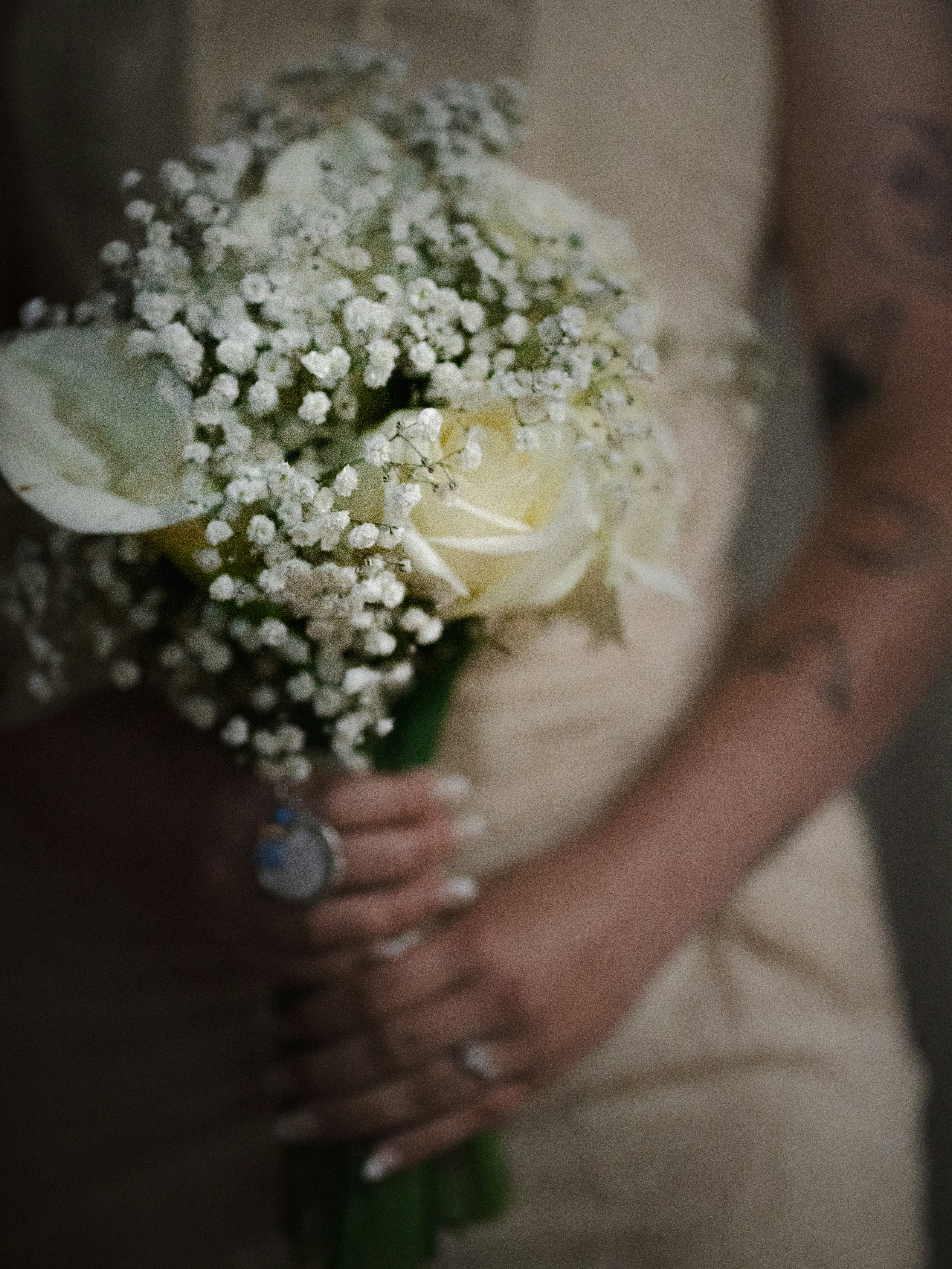 Bride holding a bouquet of white roses and baby's breath