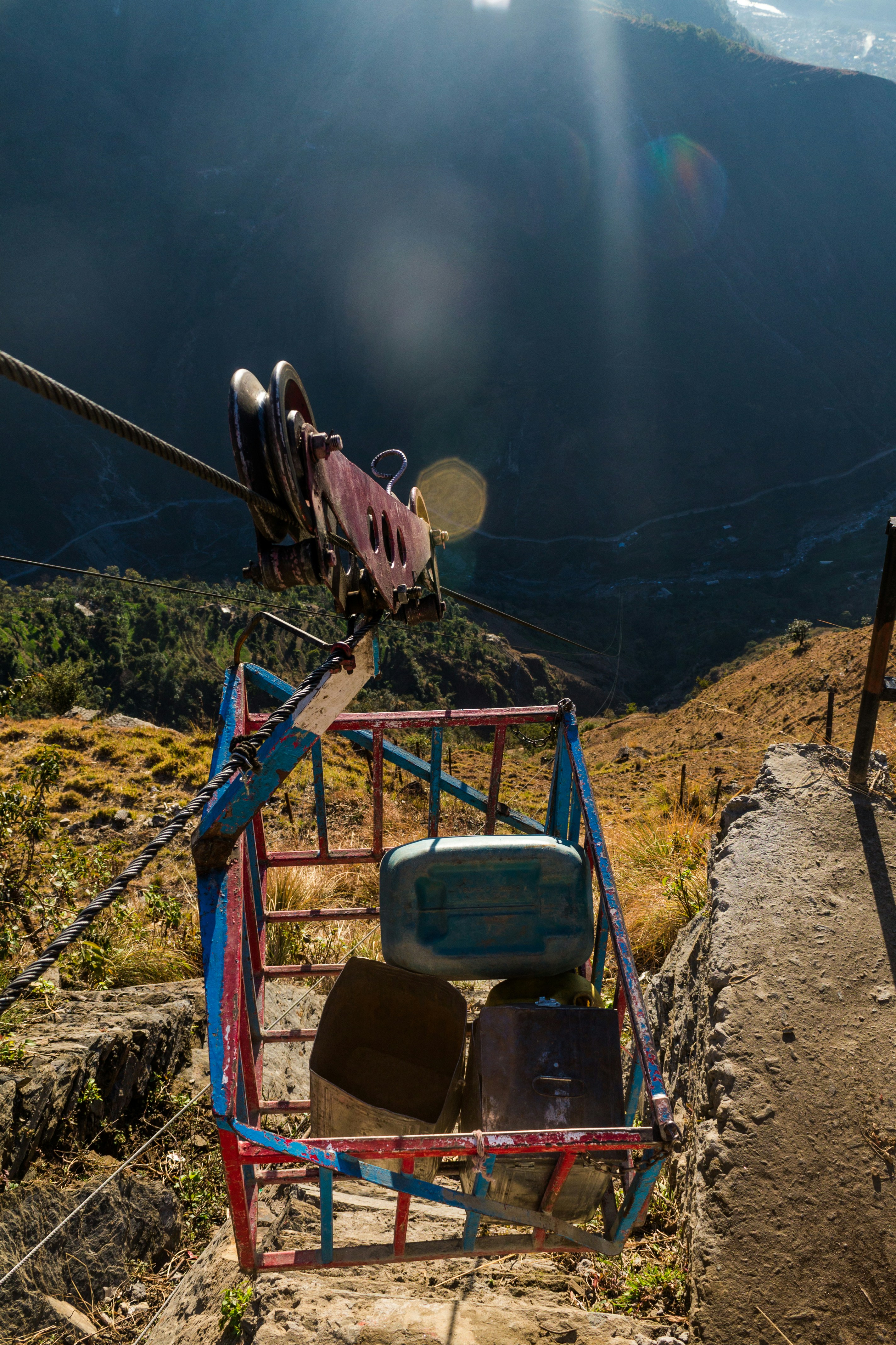 Cable car basket with containers on steep mountain path