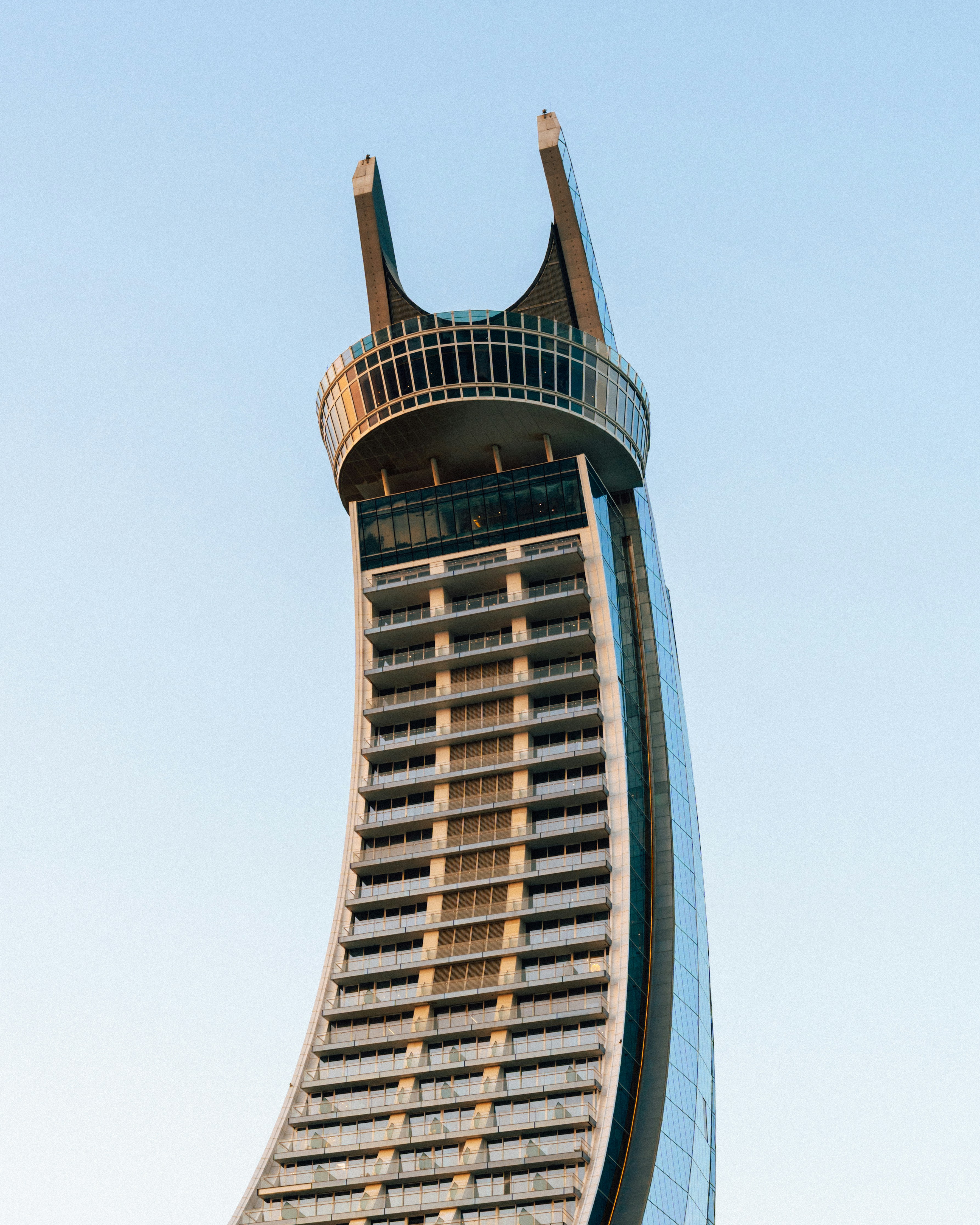 Modern skyscraper with unique curved architecture against sky