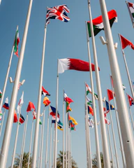 Flags of many nations waving against a blue sky