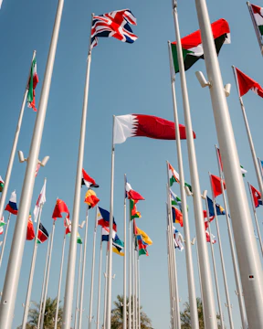 Flags of many nations waving against a blue sky