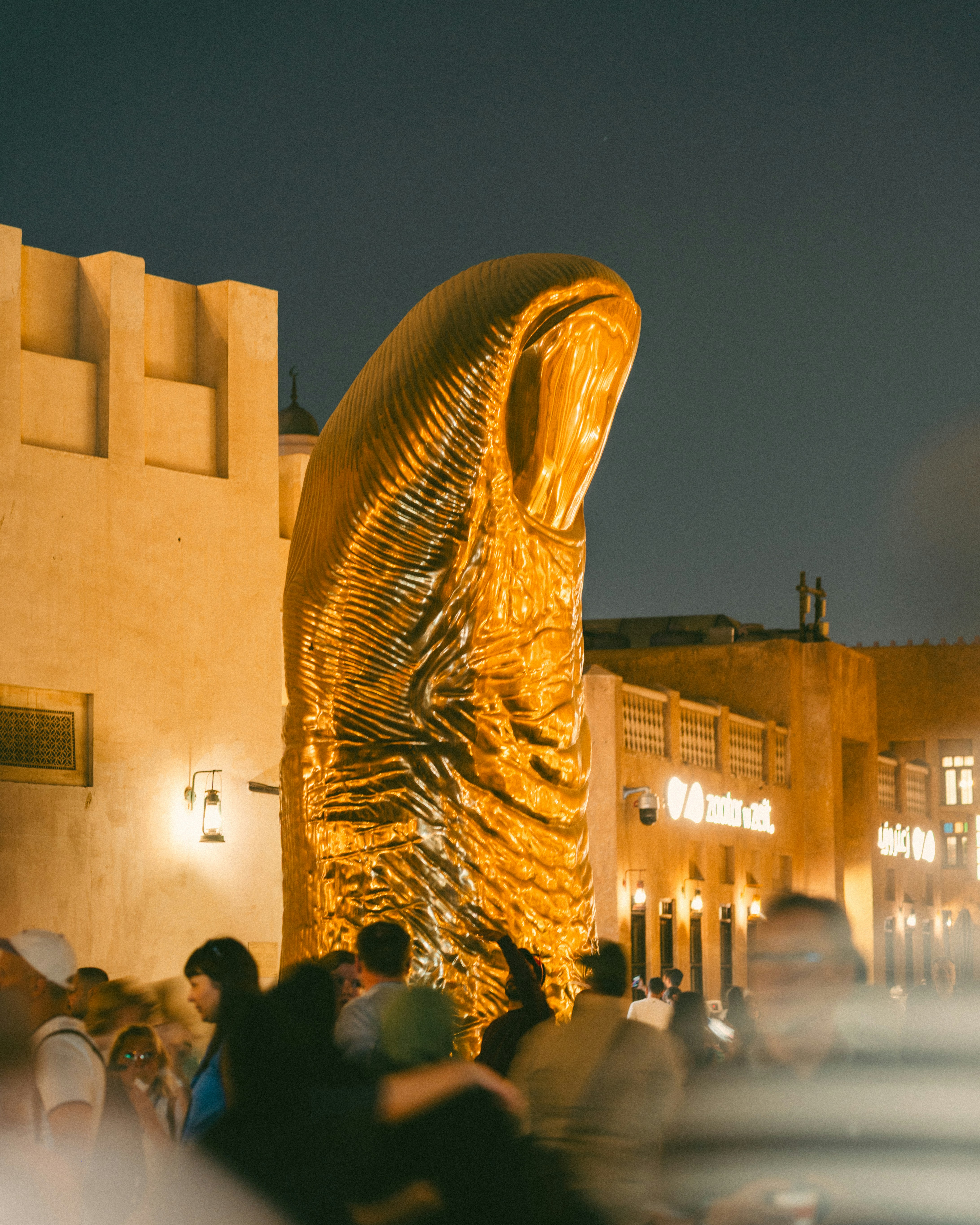 Large golden sculpture in a bustling night market
