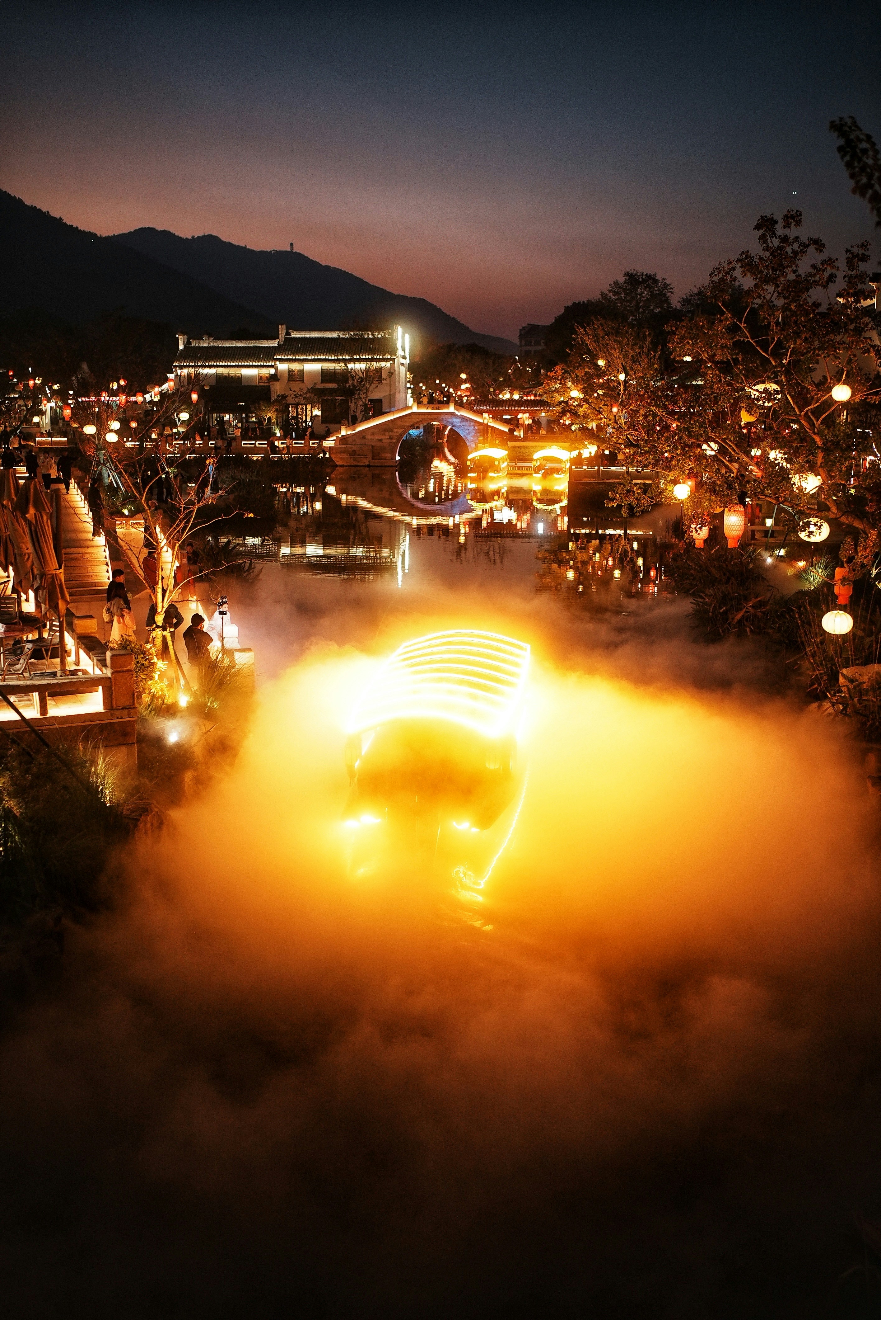 Boat illuminated by fog on a river at night.