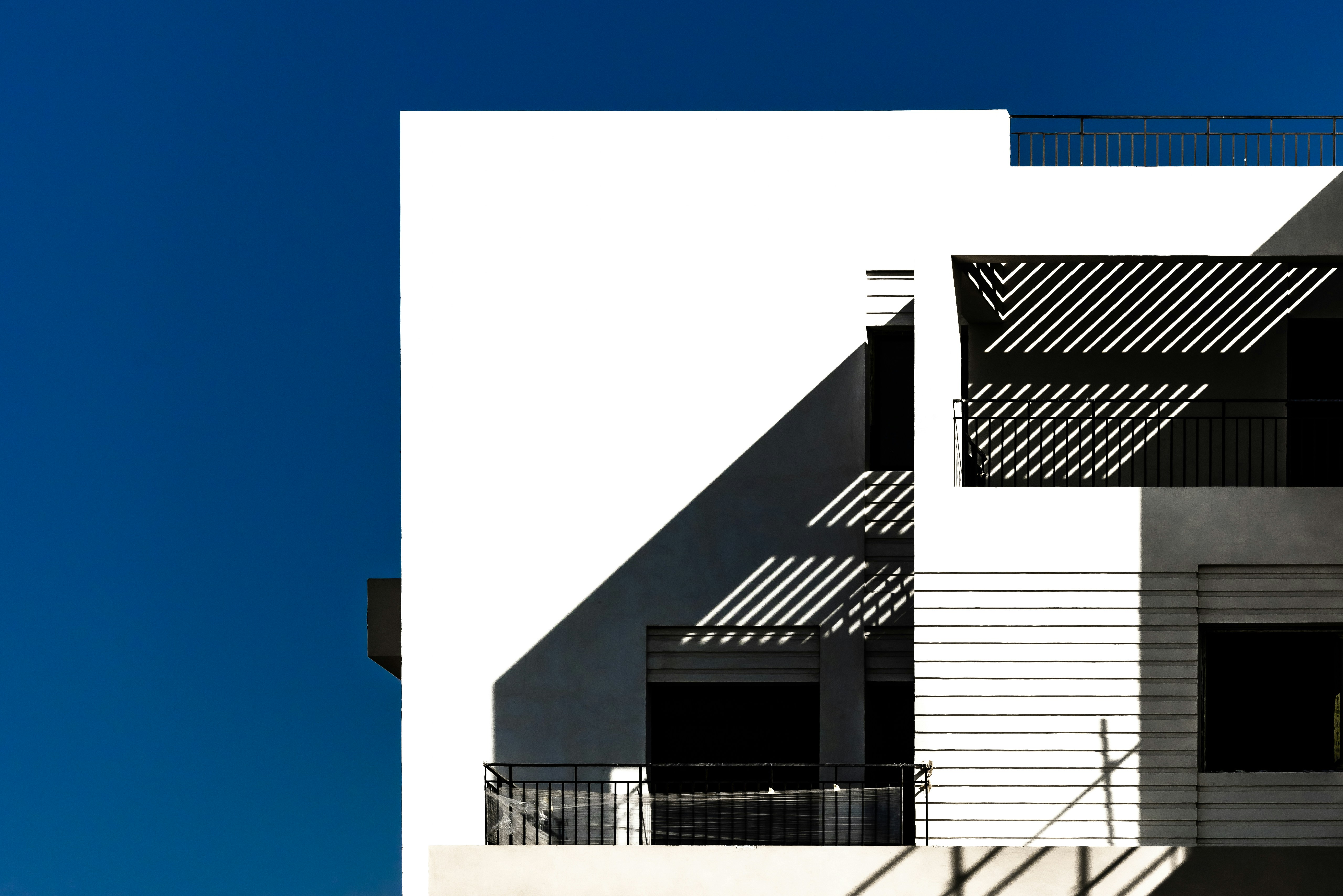 Modern white building against a bright blue sky.