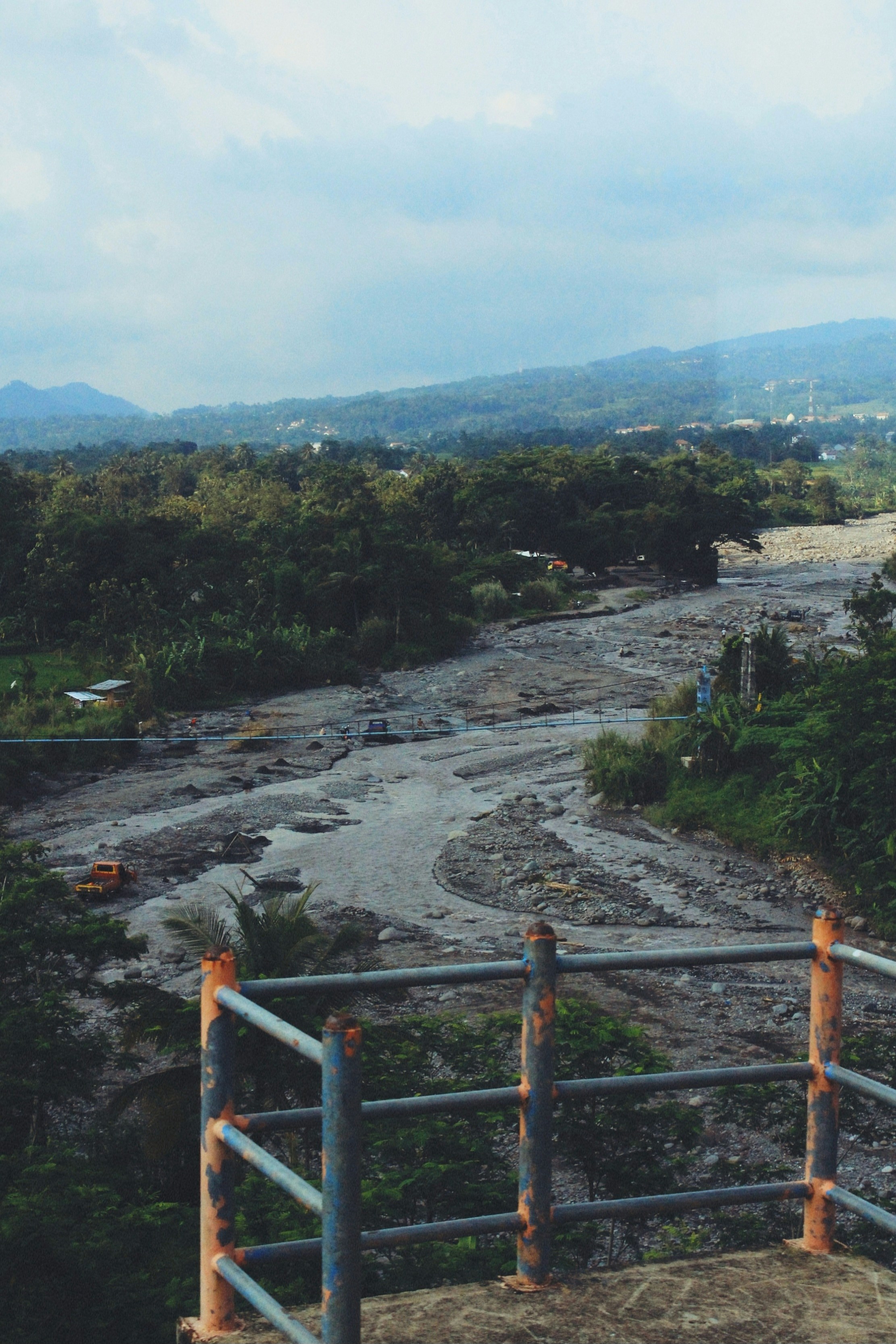 A muddy riverbed with debris and vegetation.
