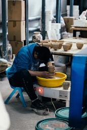 Man working on a pottery wheel creating ceramics.