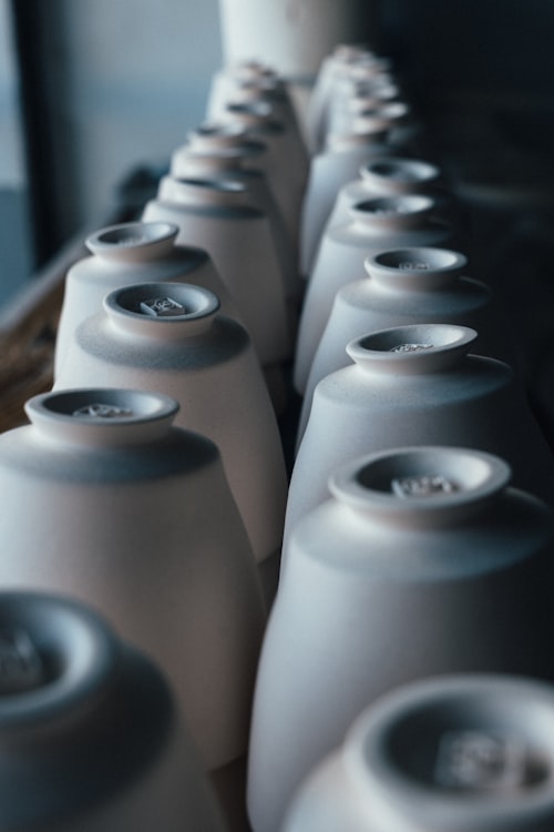 Unglazed ceramic cups drying on a shelf
