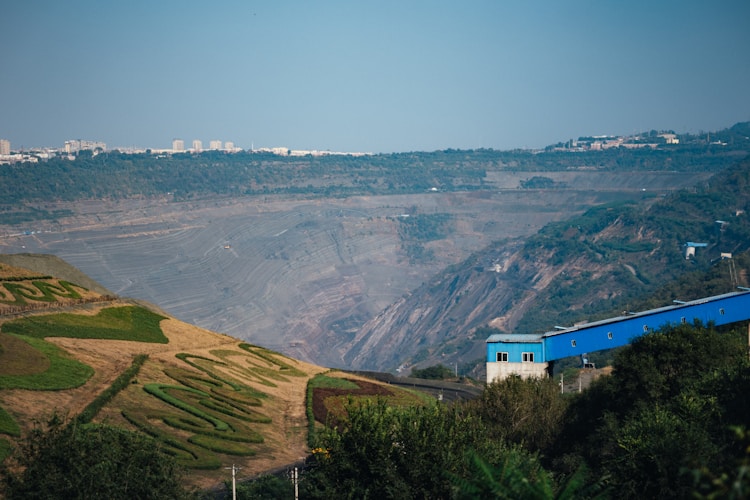 Vast open-pit mine carved into the earth, illustrating the scale and environmental impact of gold mining operations