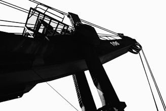 Silhouette of a large industrial crane against sky