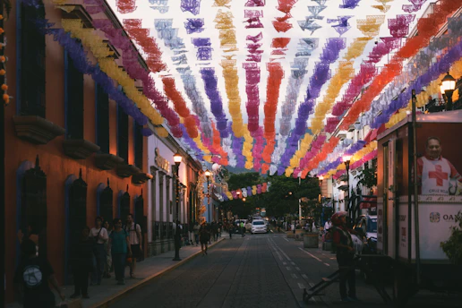 Colorful banners strung across a street at dusk.