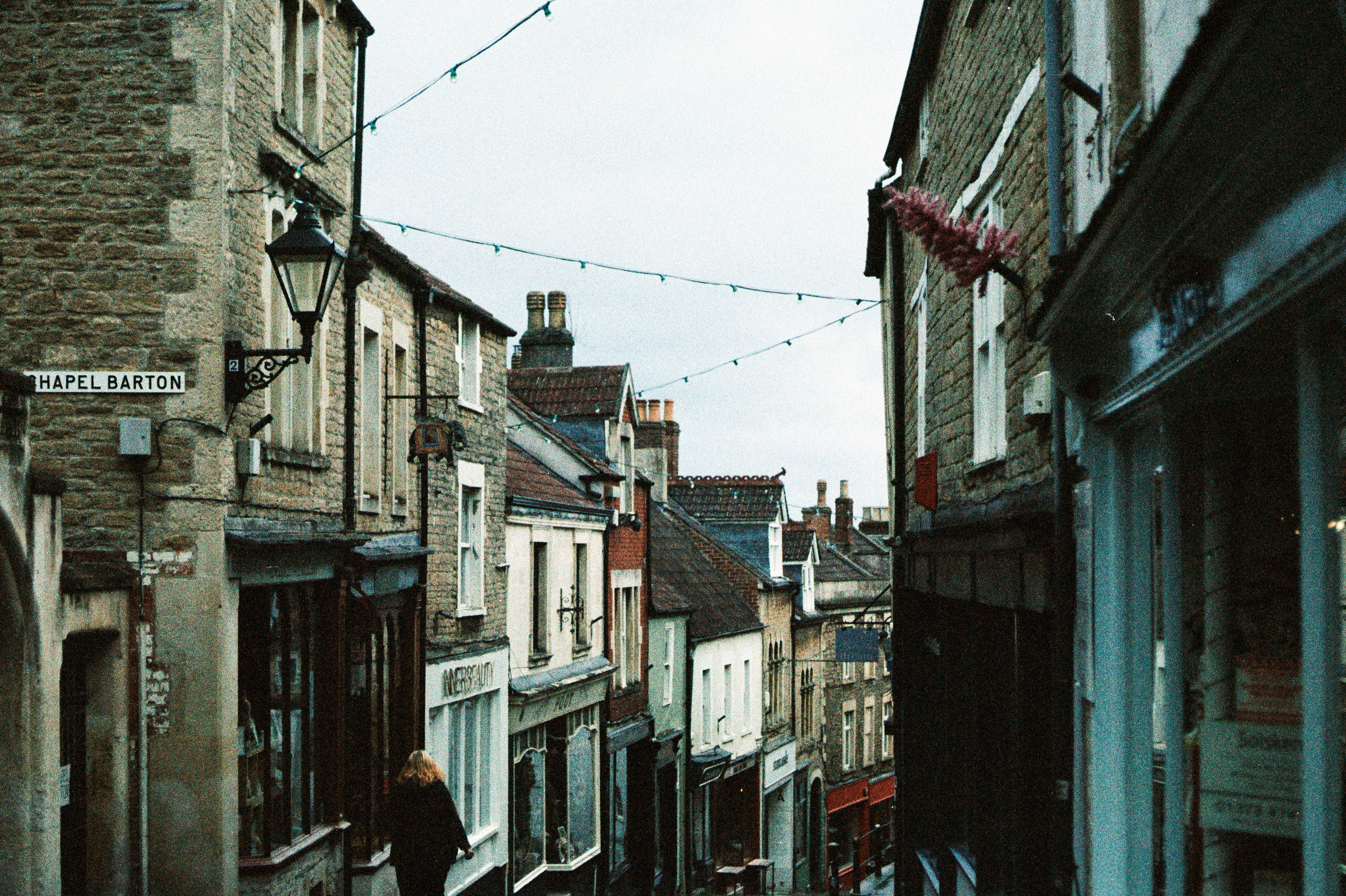 Narrow street lined with shops and buildings.