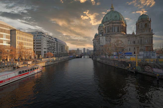 River with buildings and cathedral at sunset
