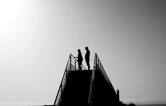 Two people silhouetted on a lookout platform