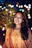 Young woman smiling with bokeh lights in background
