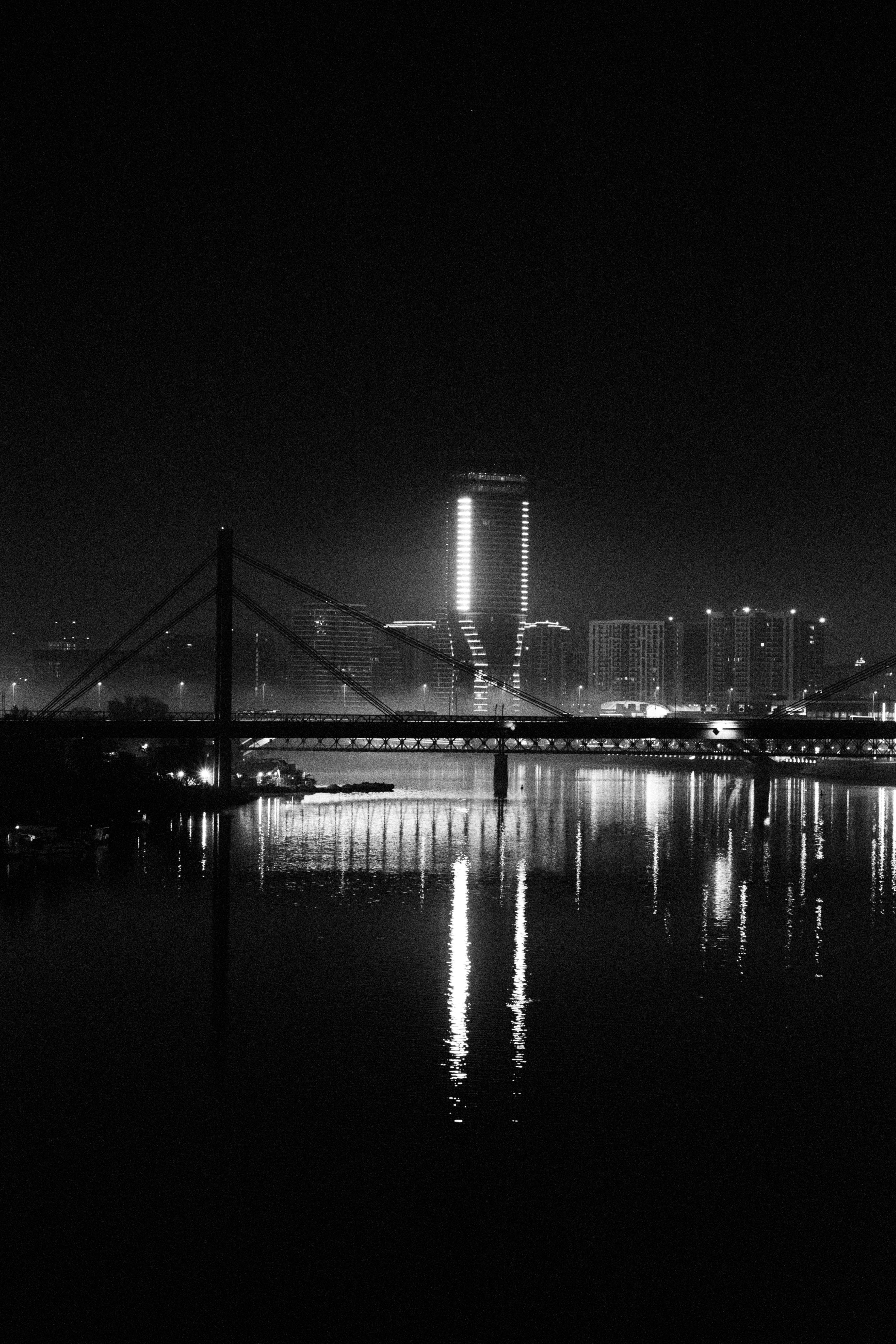 Paisagem urbana com ponte e rio à noite