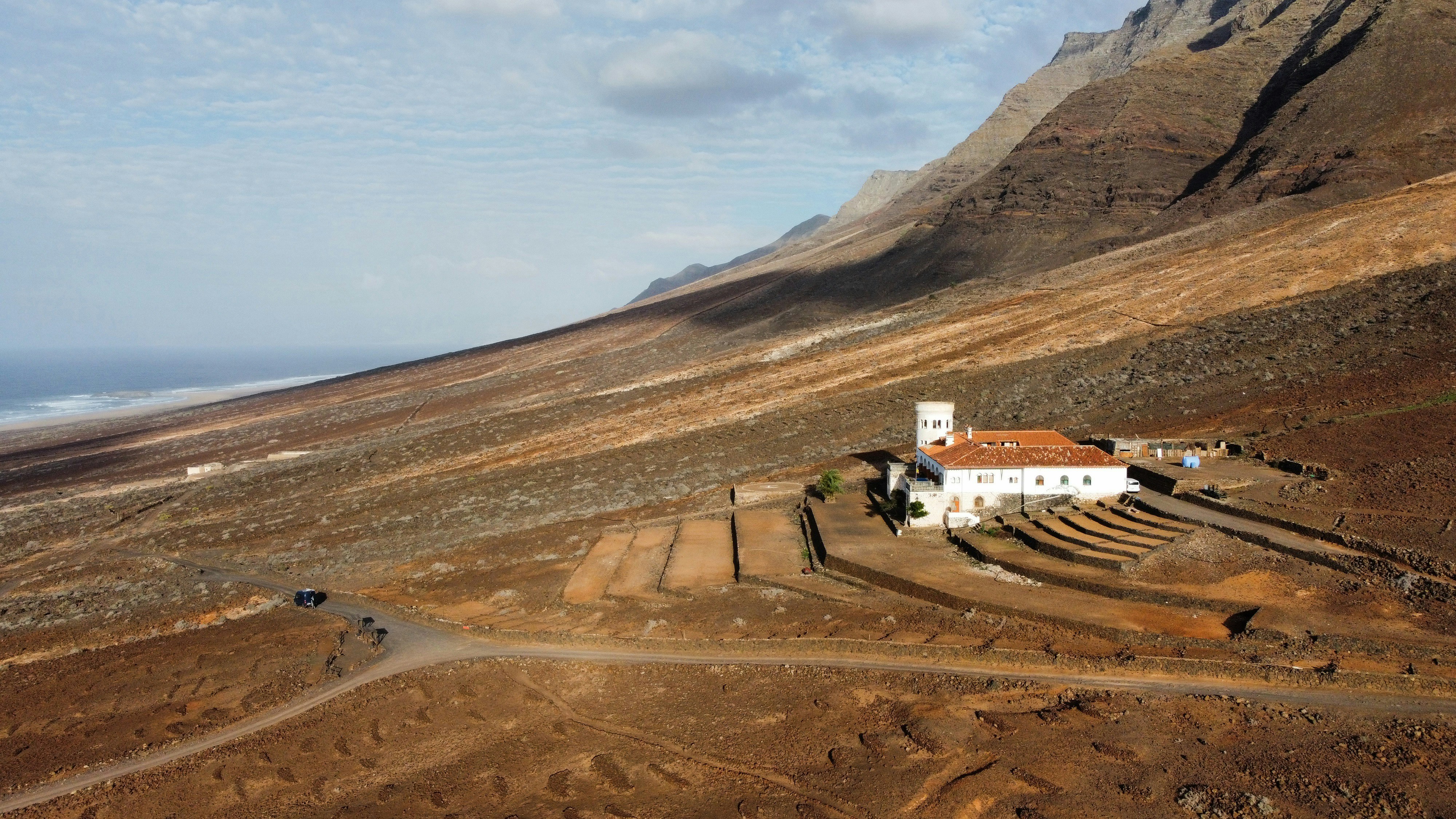 White building with red roof in arid landscape