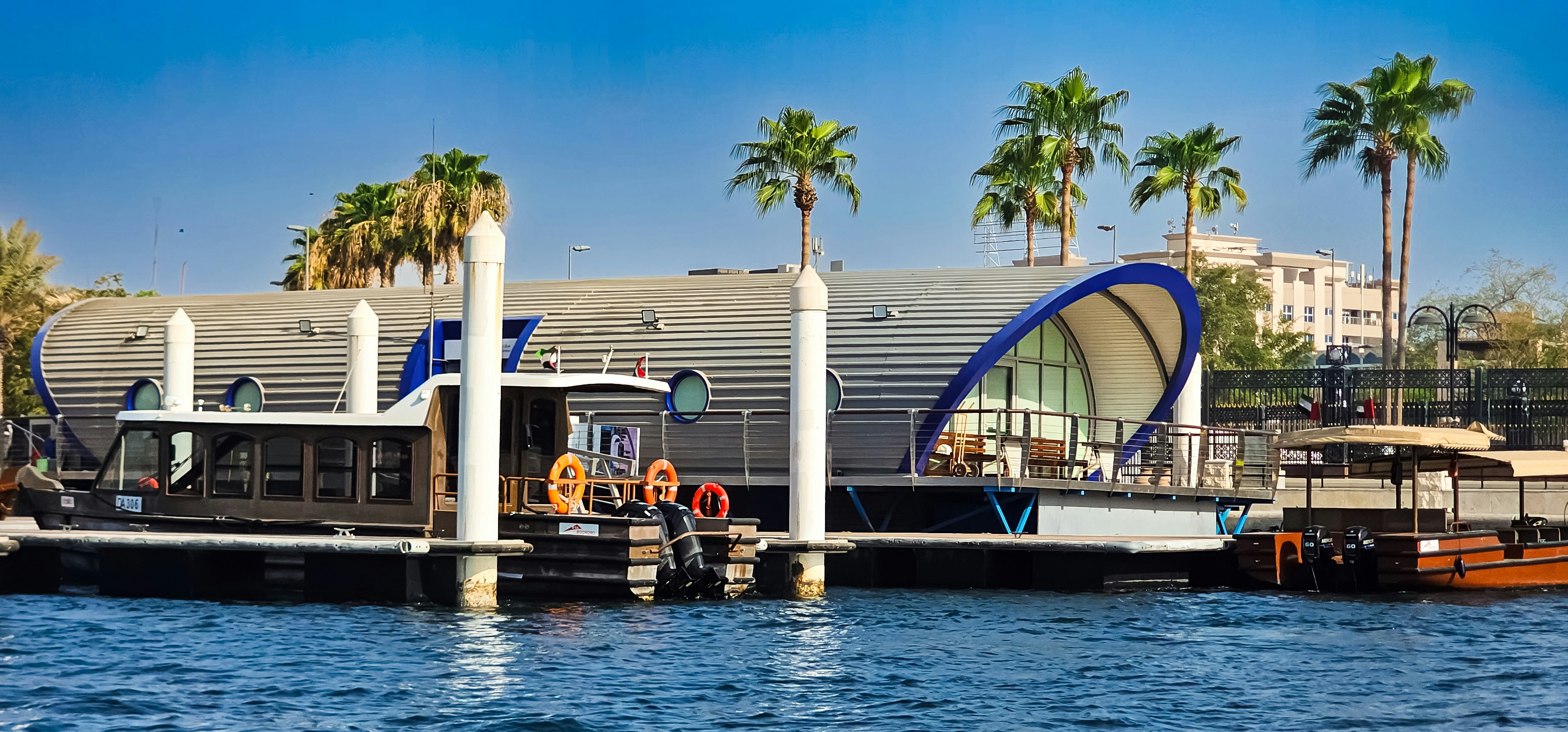 Modern building with palm trees by the water