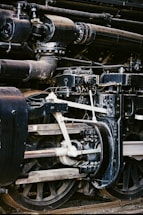 Close-up of steam locomotive engine mechanics and wheels.