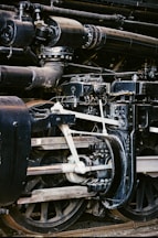 Close-up of steam locomotive engine mechanics and wheels.