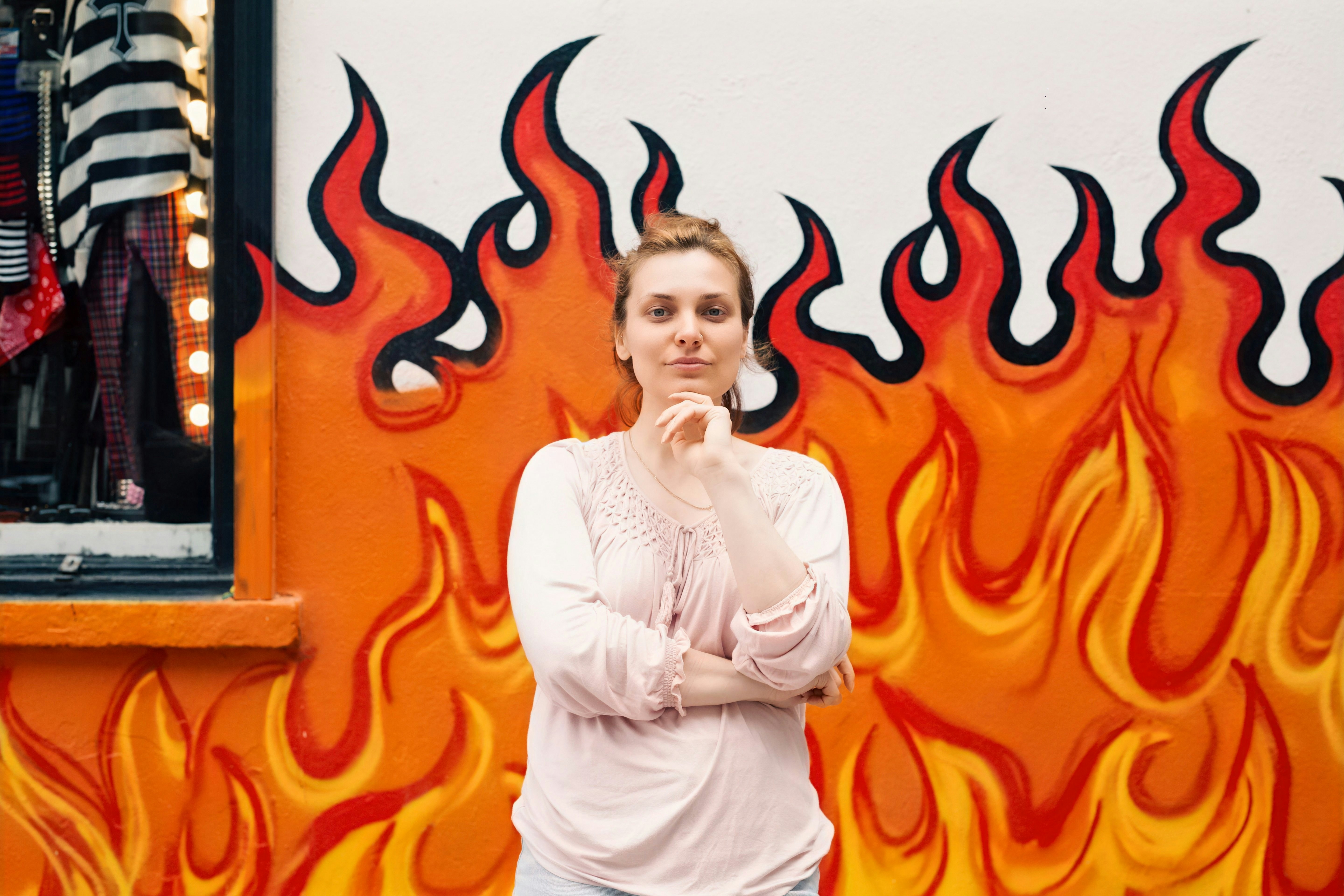 Woman in front of a flame-decorated wall