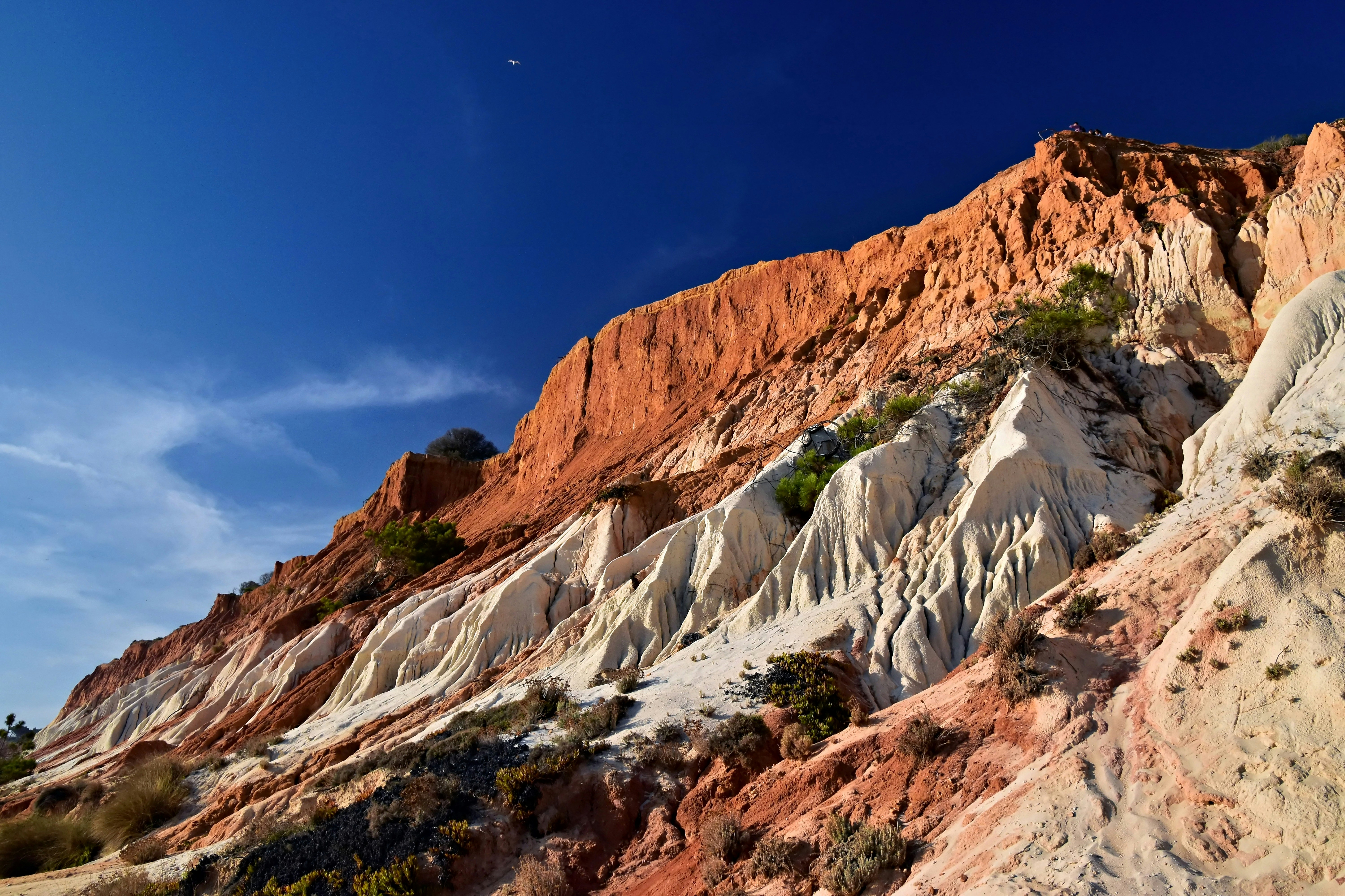Layered sandstone cliffs under a clear blue sky.
