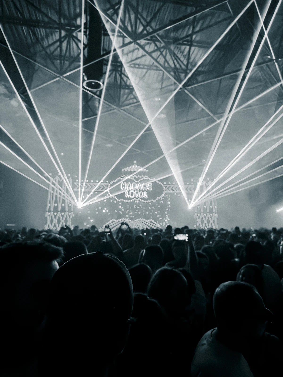 White laser beams spanning a packed concert venue