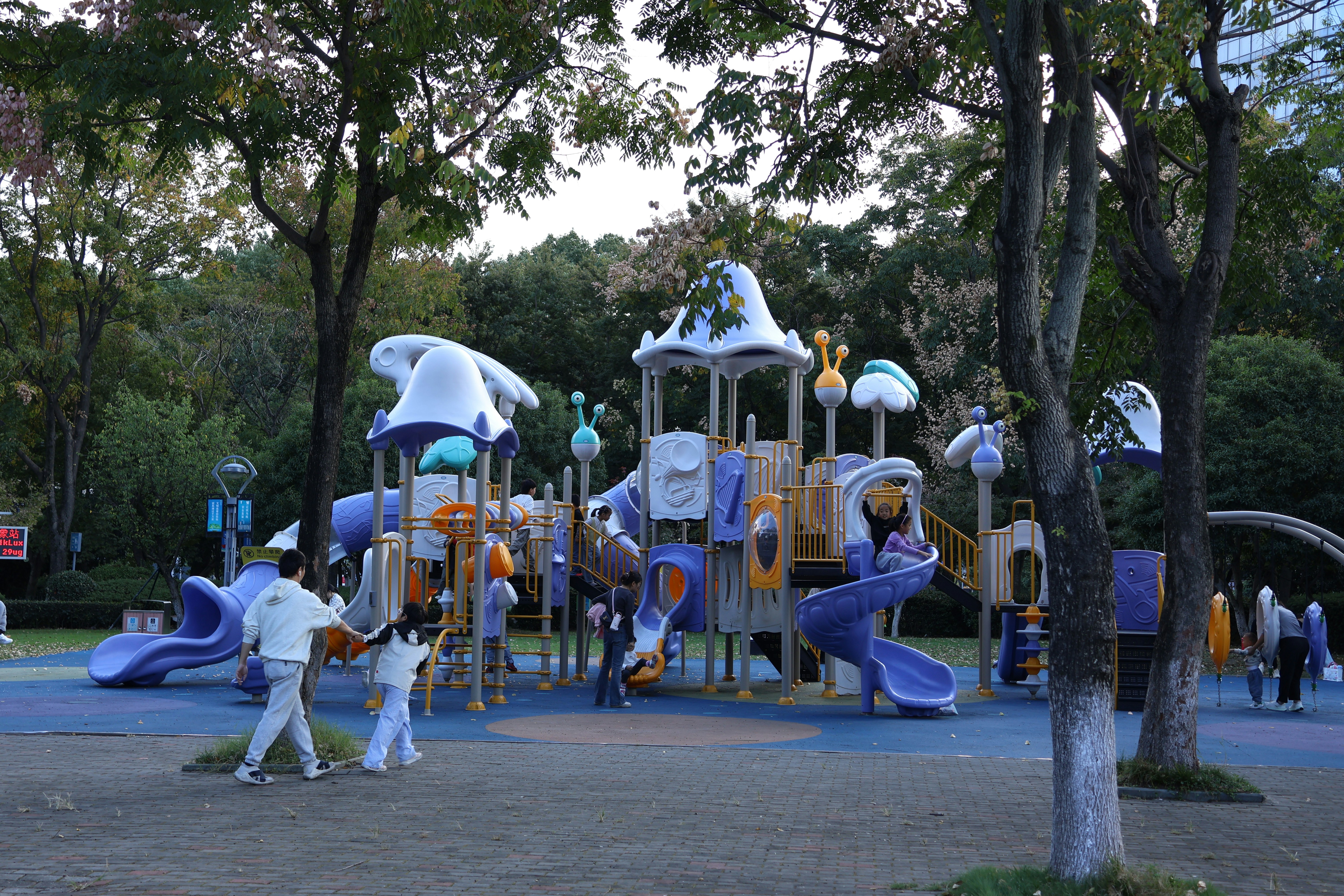 Colorful playground equipment in a park with trees