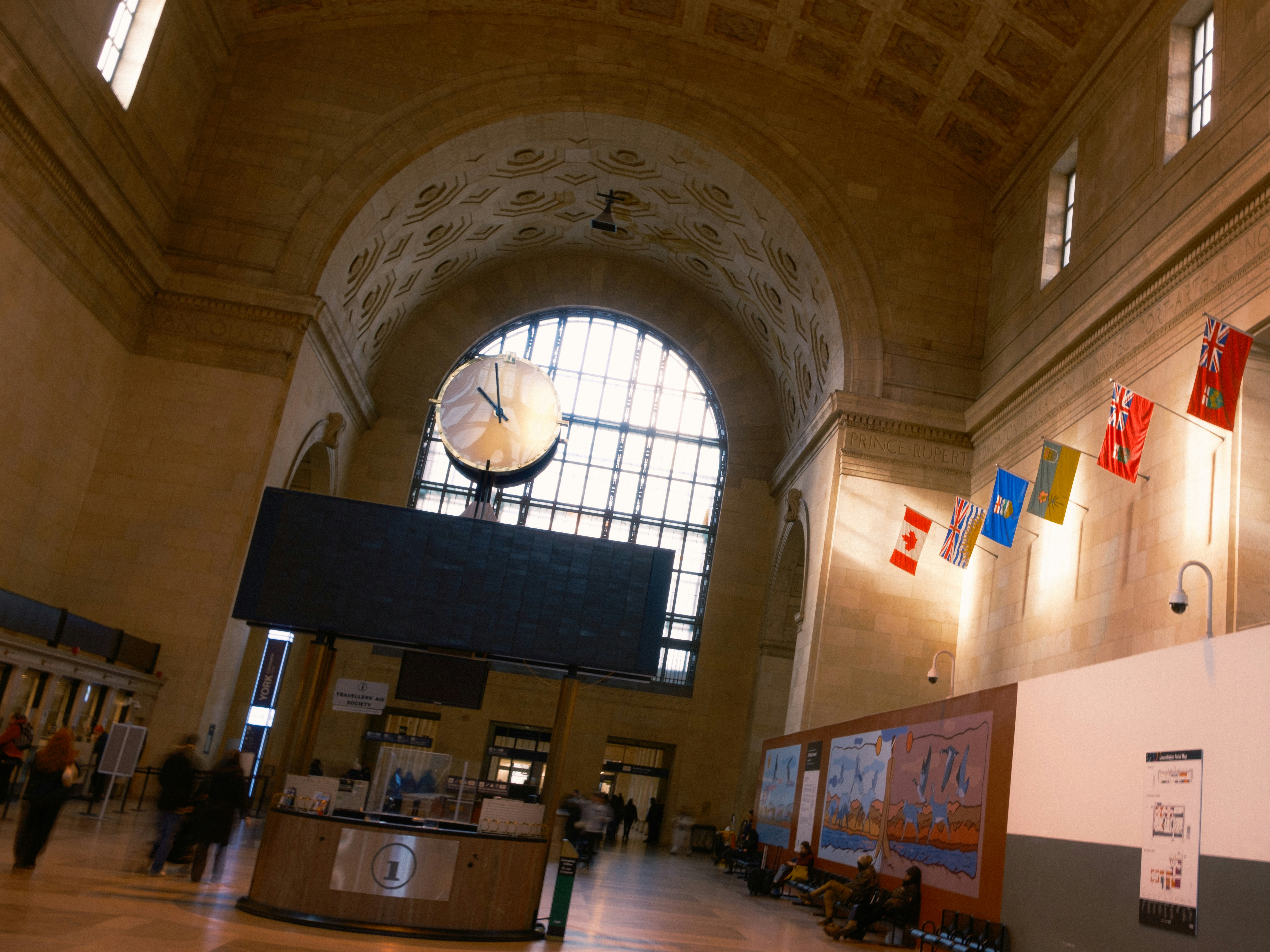 Großes Interieur eines Bahnhofs mit großer Uhr.