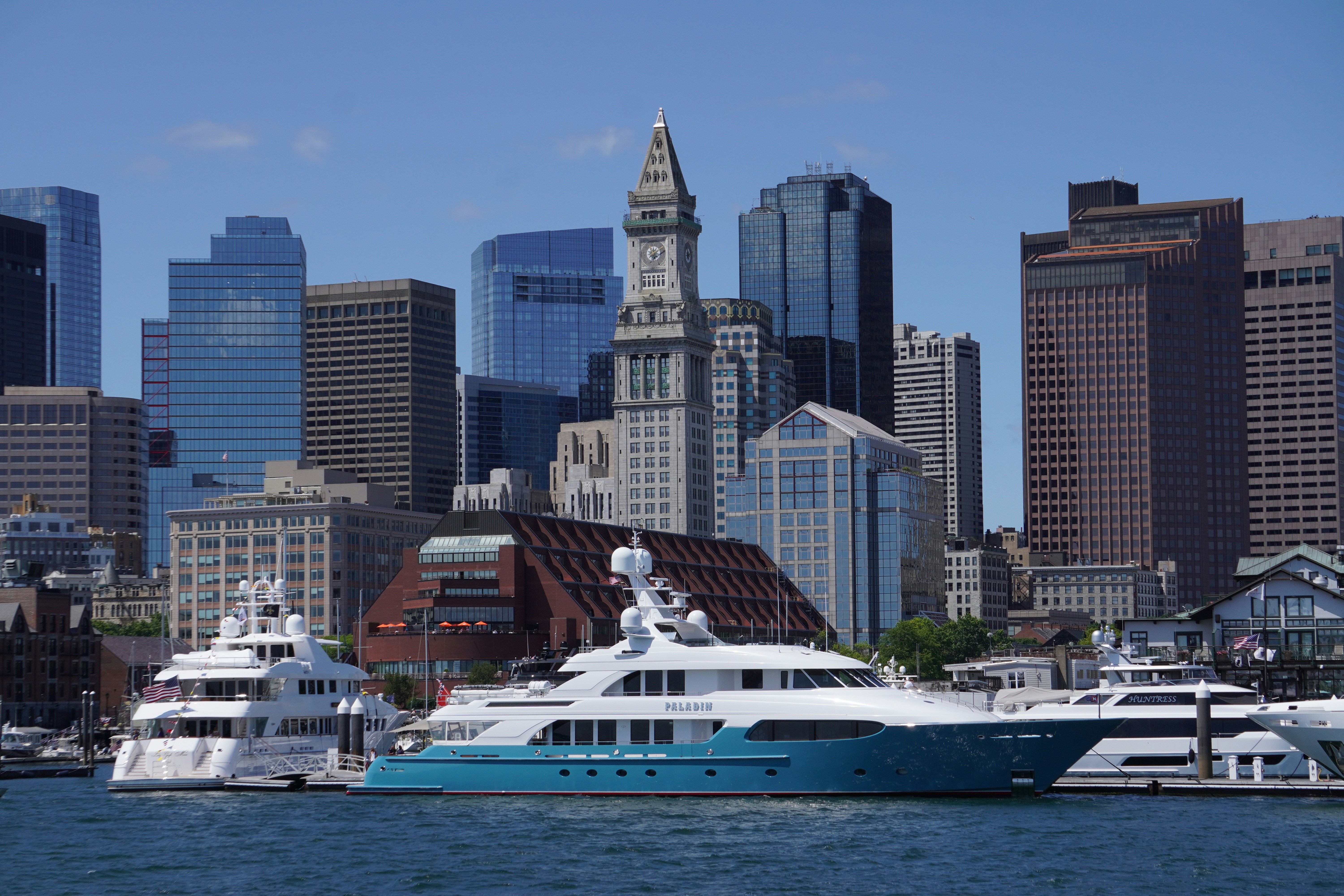 Yachts docked in front of a city skyline.