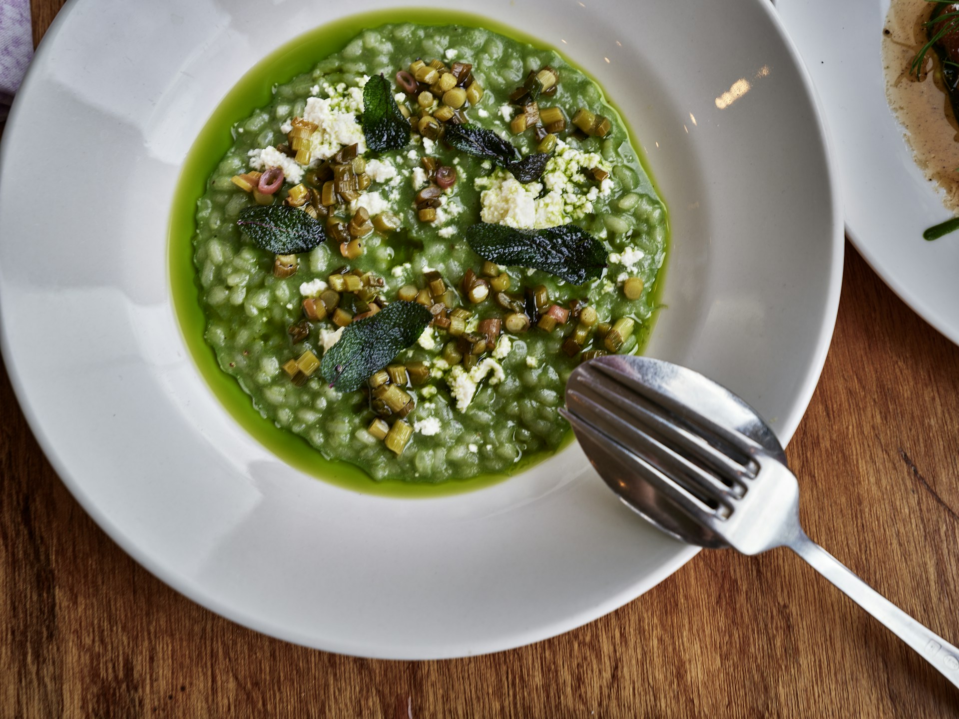 Green risotto with white cheese and herbs